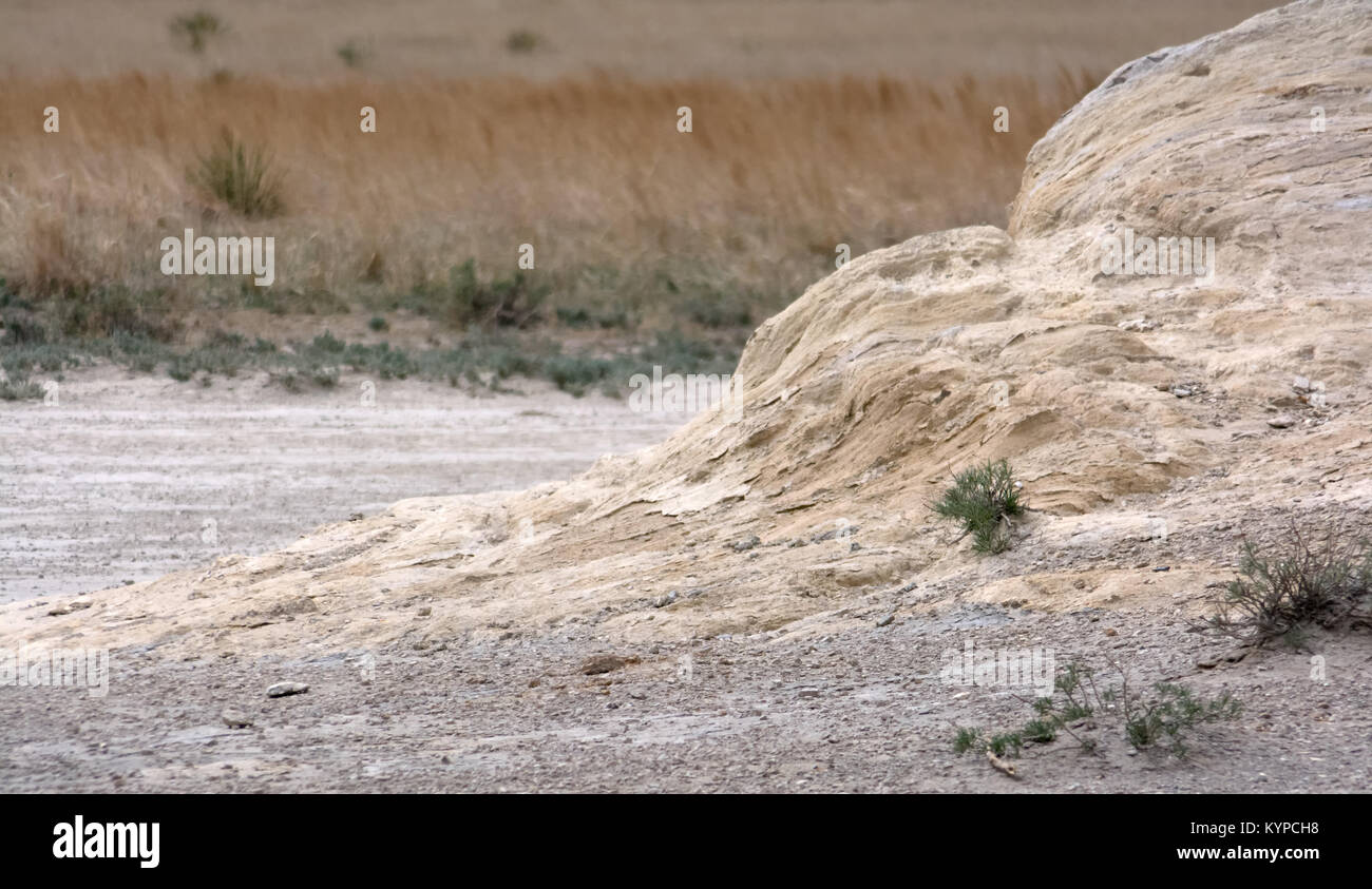 Rising from a grey gravel bed a sandstone rock froms a ramp leading up ...