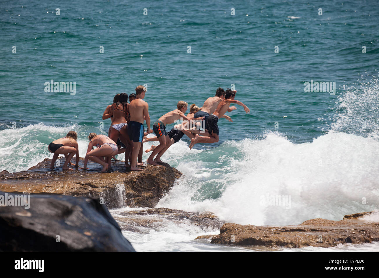 Teenagers diving into the surf at Manly Beach Australia Stock Photo