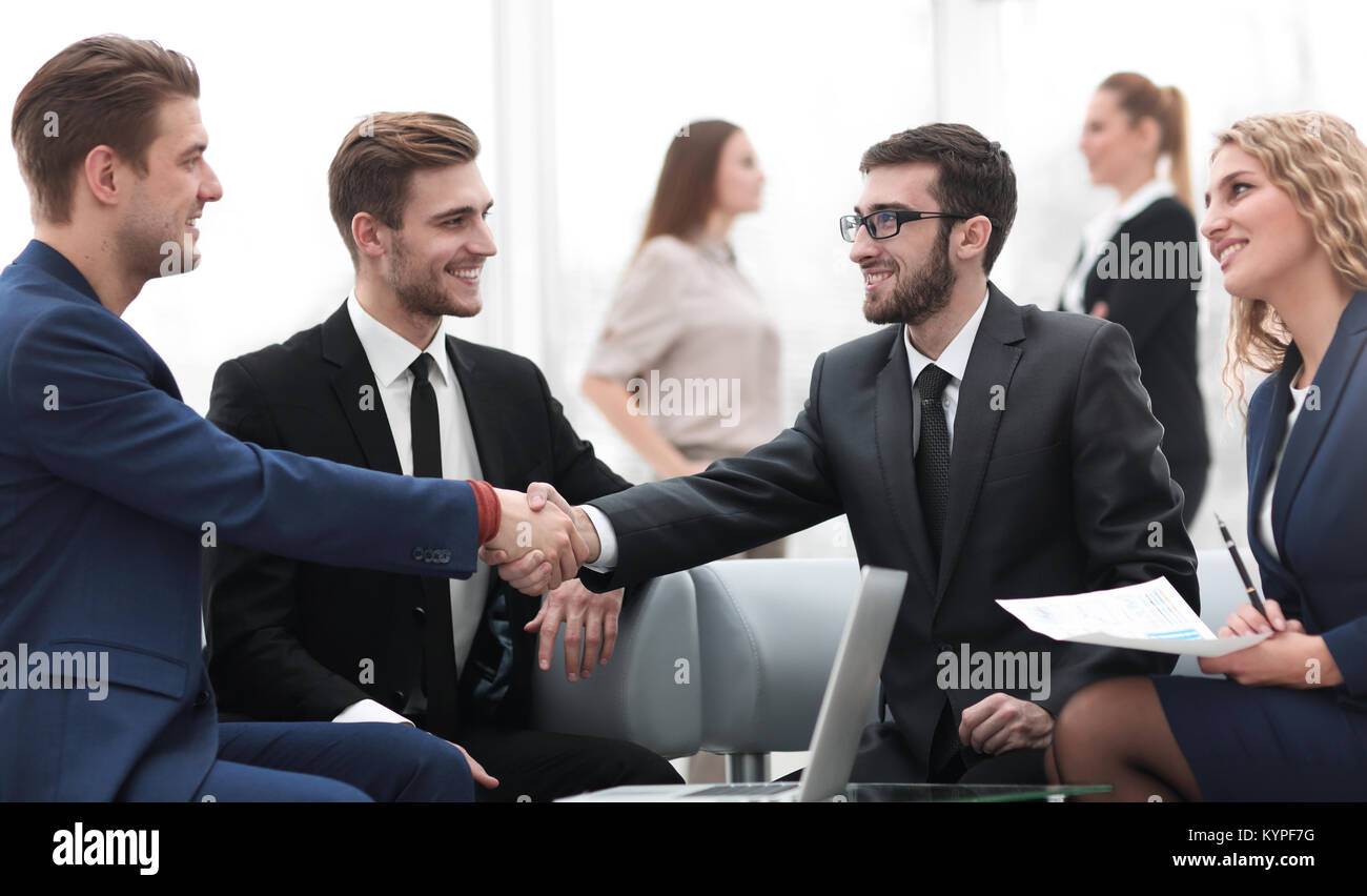 Partners concluding deal and shaking hands in the presence of team ...
