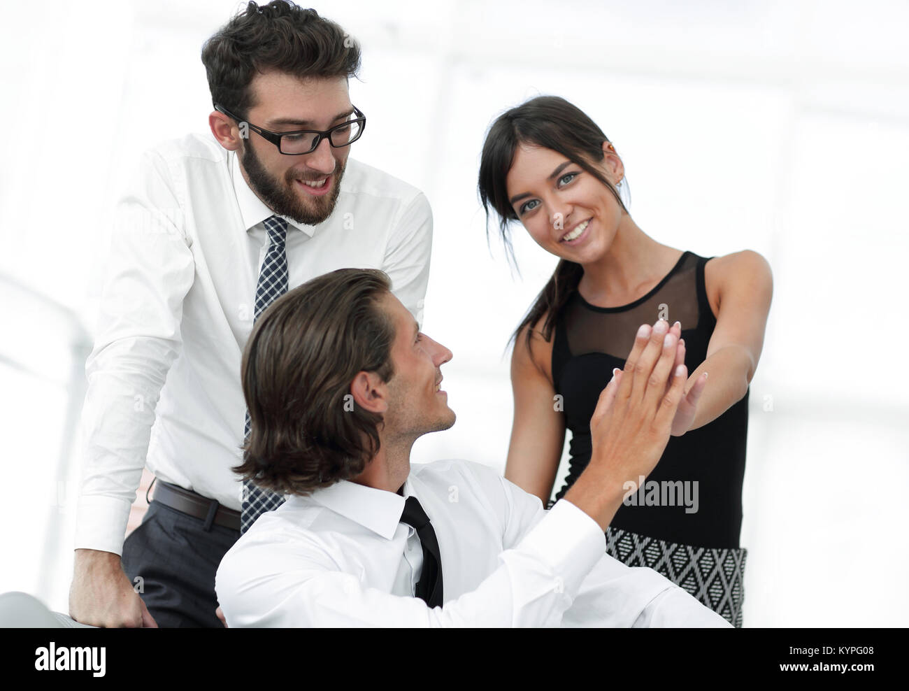 Young business colleagues giving each other a high five Stock Photo - Alamy