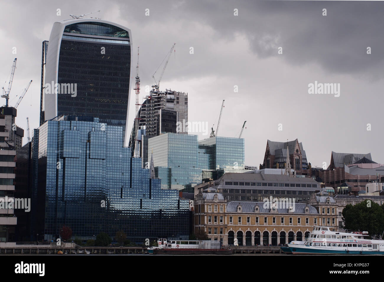 A view over to the city of London with Thames river boats in the foreground taken from the southern bank of the Thames near London Bridge Stock Photo