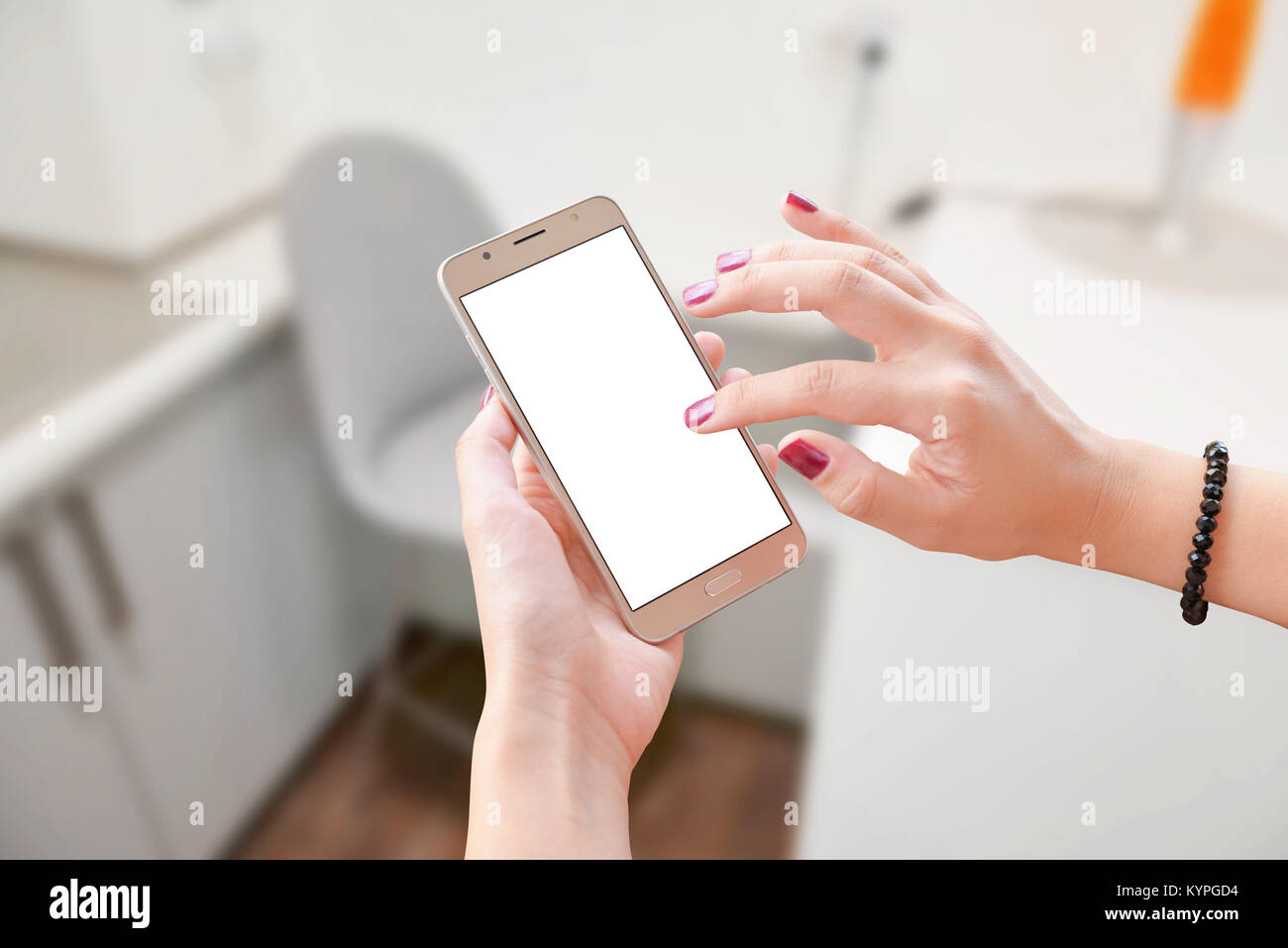 Woman touch smart phone with blank isolated screen for app presentation. Office in background. Stock Photo