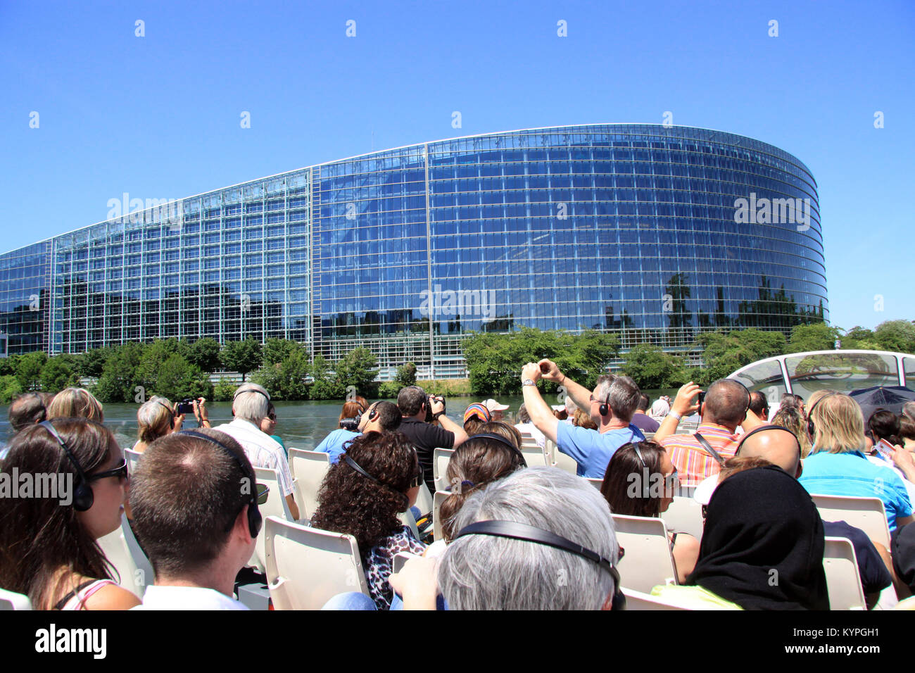 Tourists and holiday makers on a river boat trip around Strasbourg France view and photograph the European Parliament and court of human rights Stock Photo