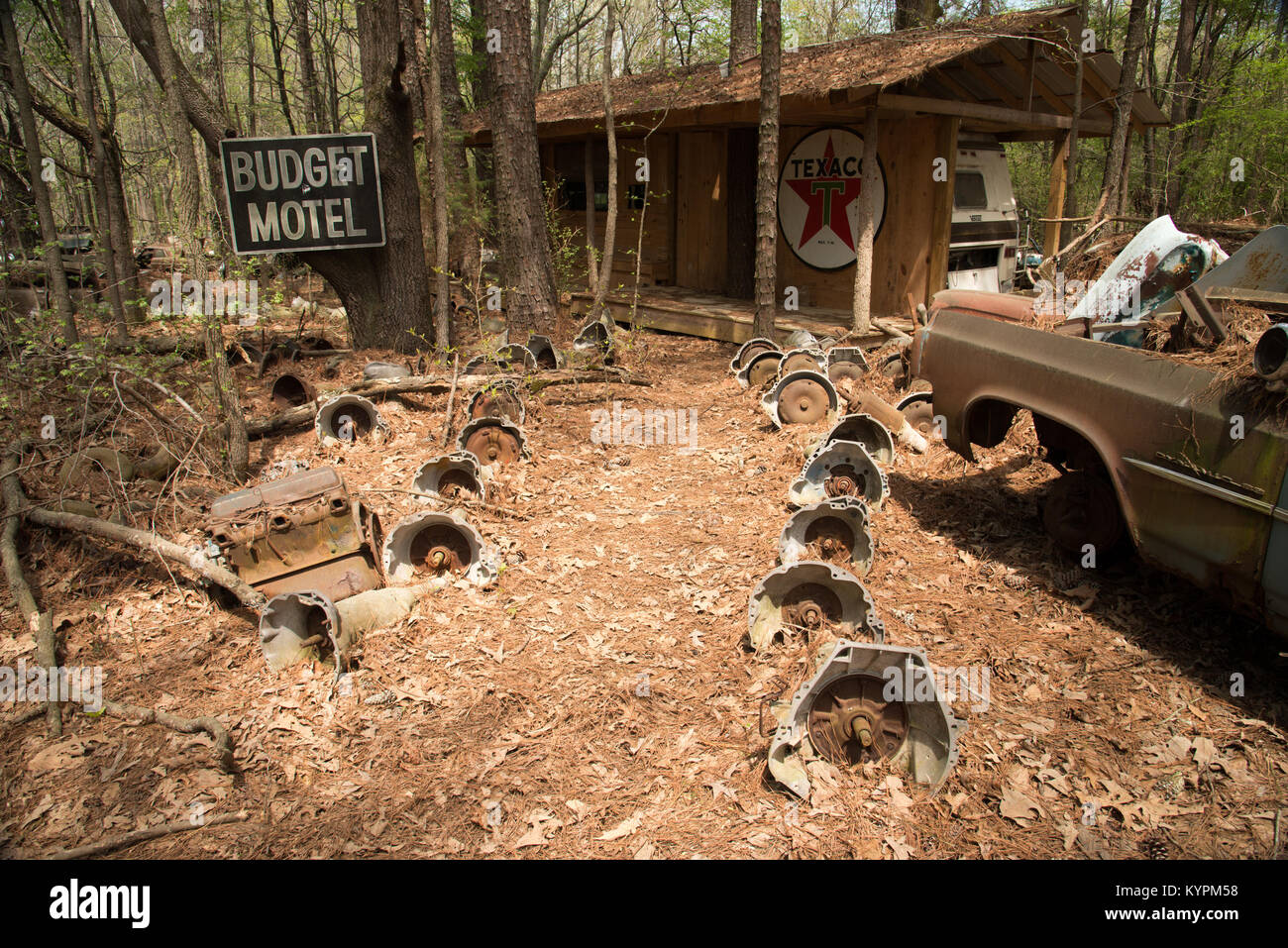 Budget Motel sign with path lined by old automobile transmission parts at Old Car City, White, Georgia, USA - Stock Image