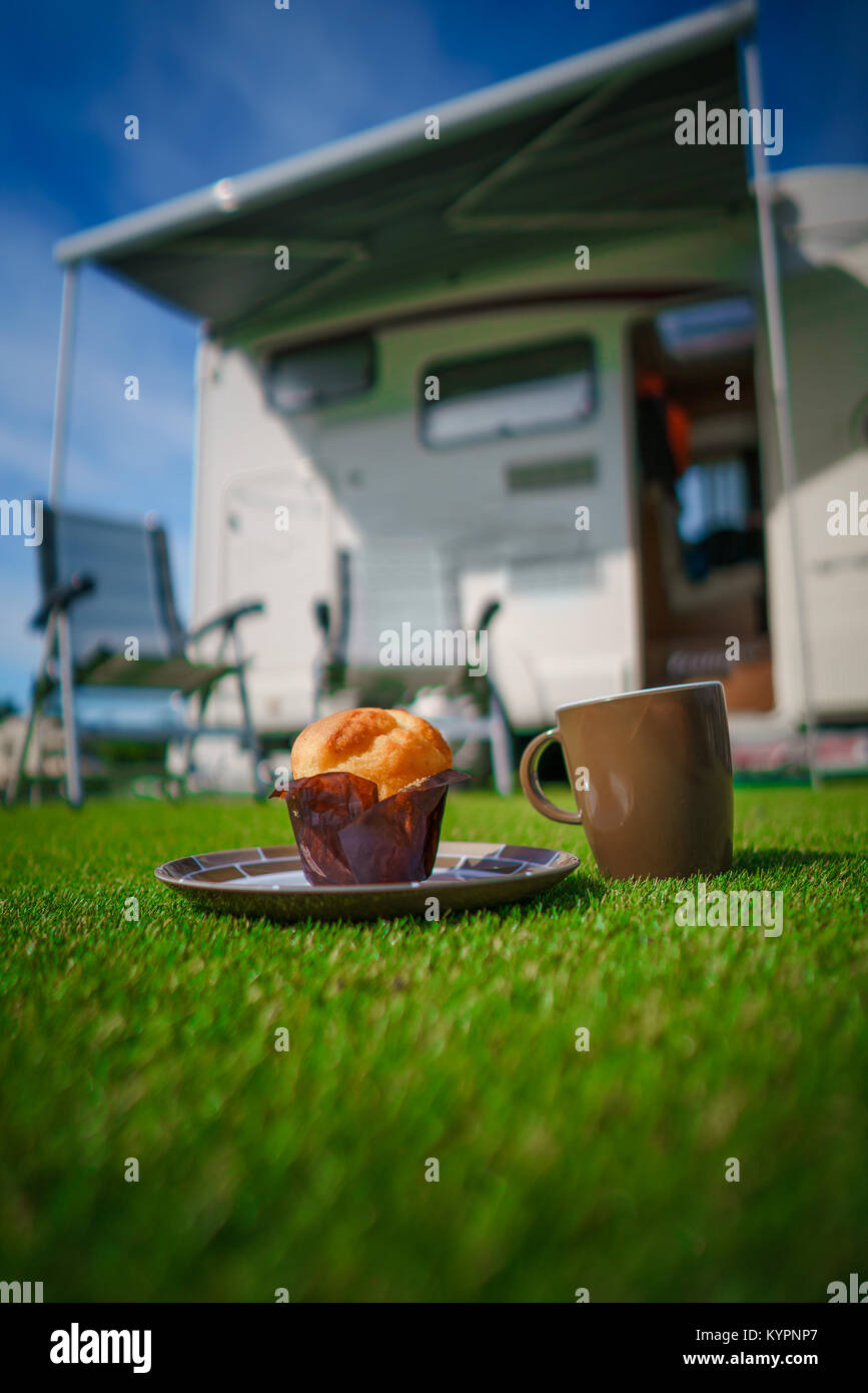 https://c8.alamy.com/comp/KYPNP7/muffin-and-coffee-mug-on-grass-caravan-car-vacation-family-vacation-KYPNP7.jpg