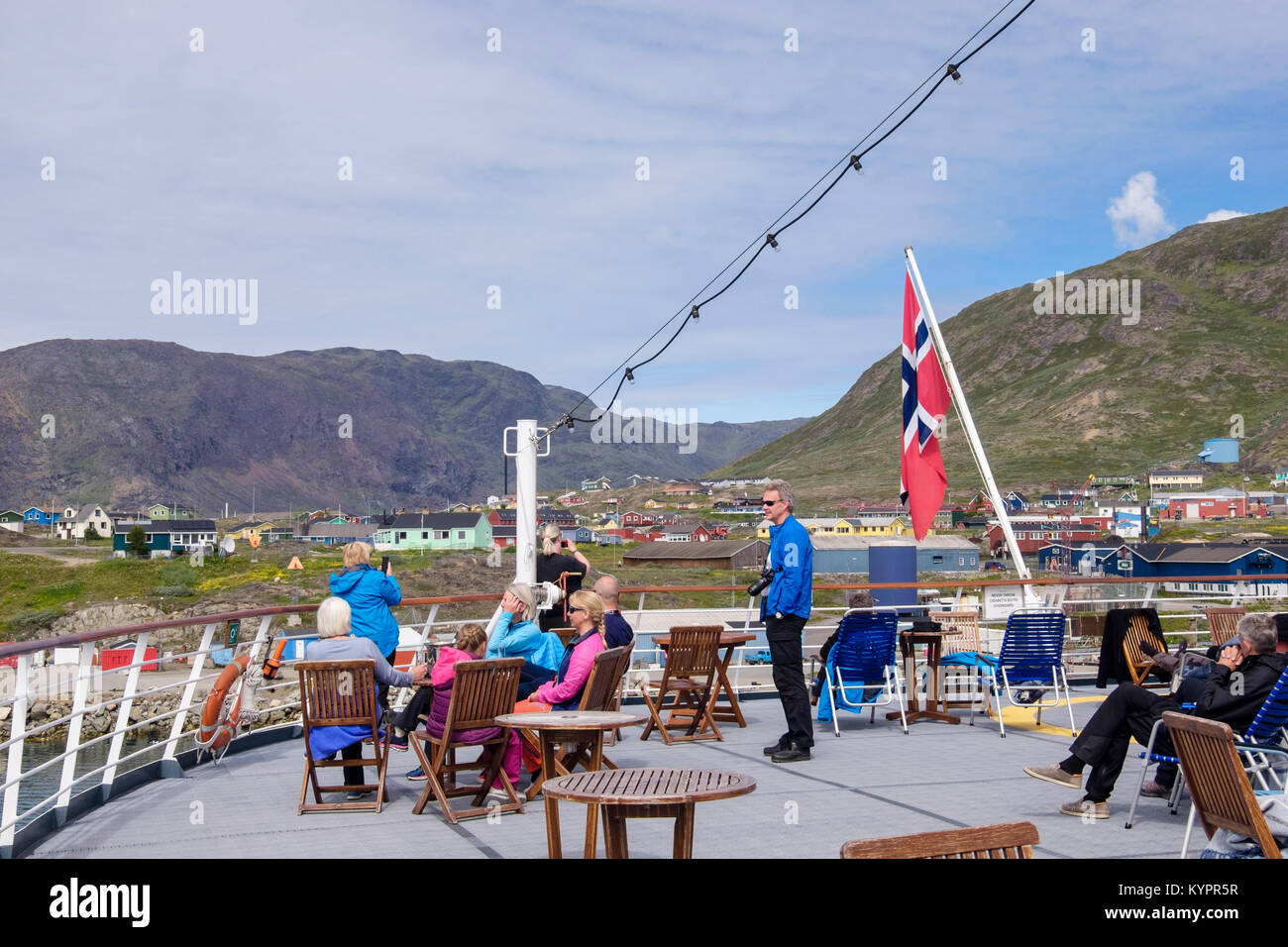 Passengers enjoying sunshine on sun deck of Hurtigruten's MS Fram explorer cruise ship sailing out of Narsaq, Kujalleq, South Greenland Stock Photo