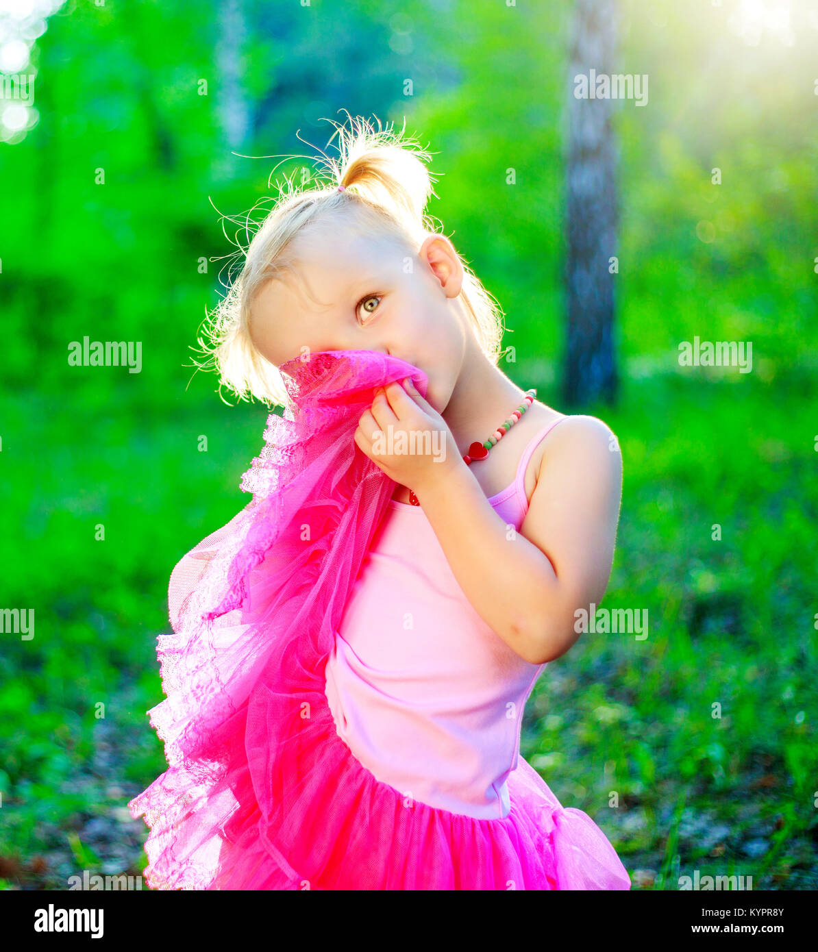 happy little girl wearing a pink dress, in the summer park Stock Photo ...