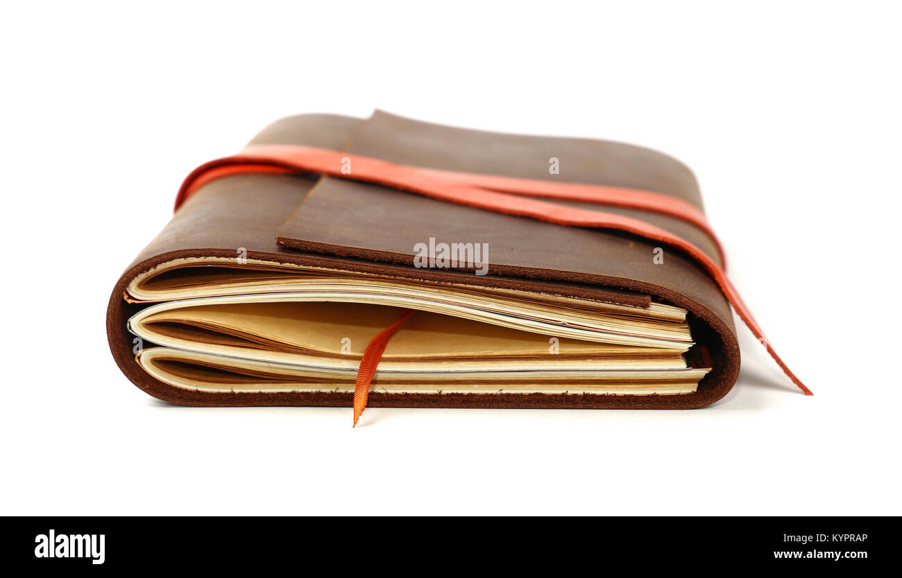 Close up of one vintage style jotter notebook with old leather cover and orange bookmark strap, isolated on white, low angle view Stock Photo