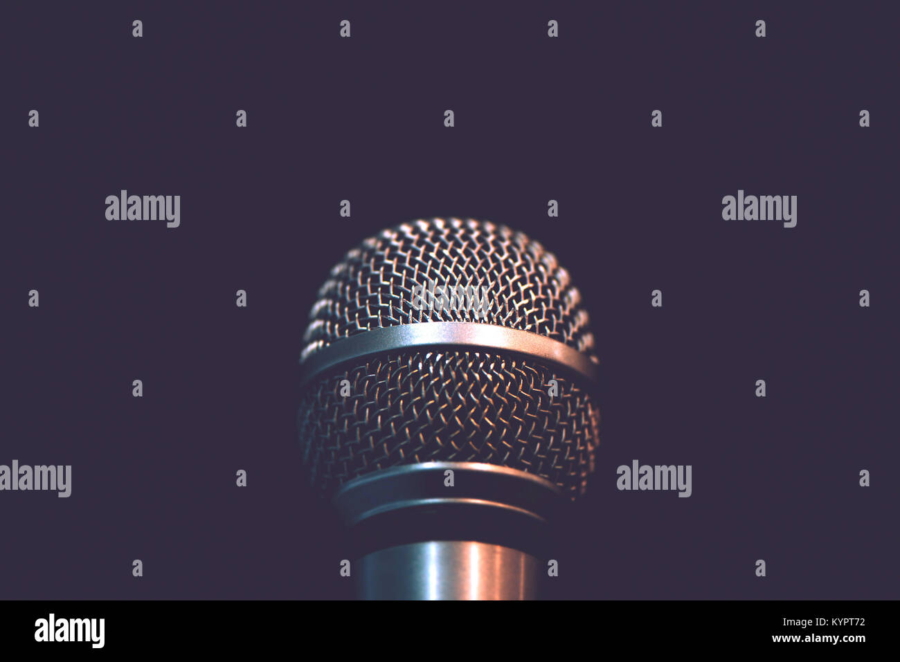 Audio microphone isolated on dark background. Music concert or talent show concept with copy space. Stock Photo