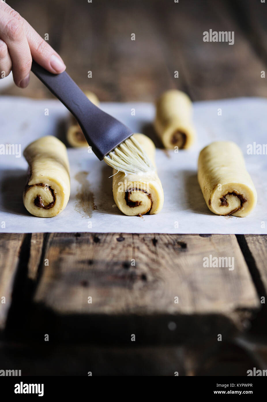 Raw cinnamon buns on wooden table before baking Stock Photo