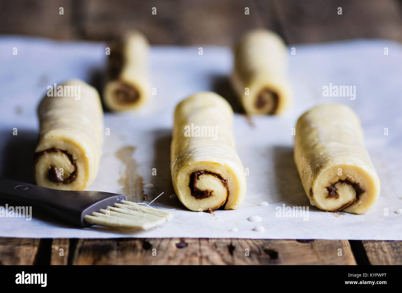 Raw cinnamon buns on wooden table before baking Stock Photo