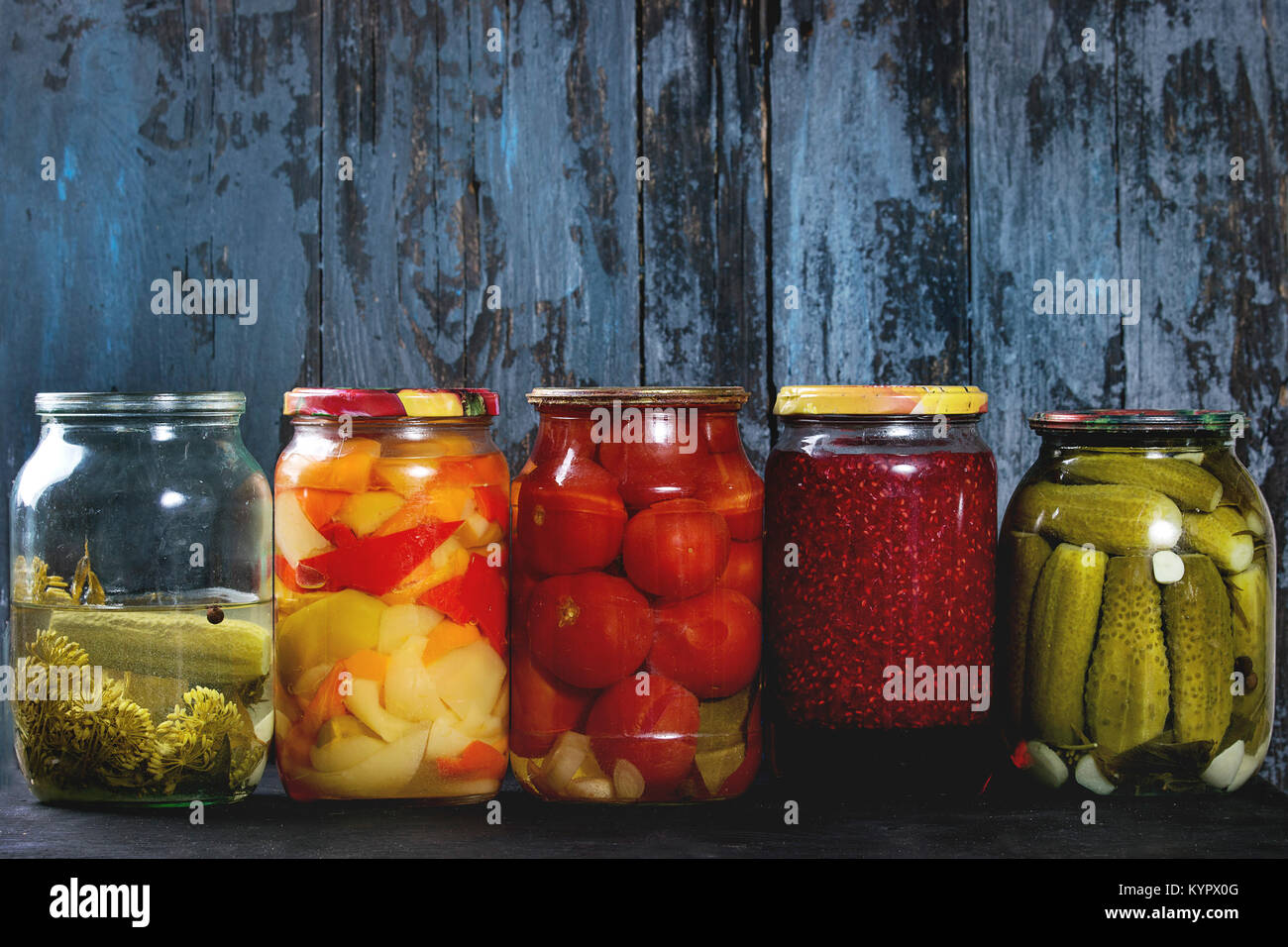 Variety glass jars of homemade pickled or fermented vegetables and jams