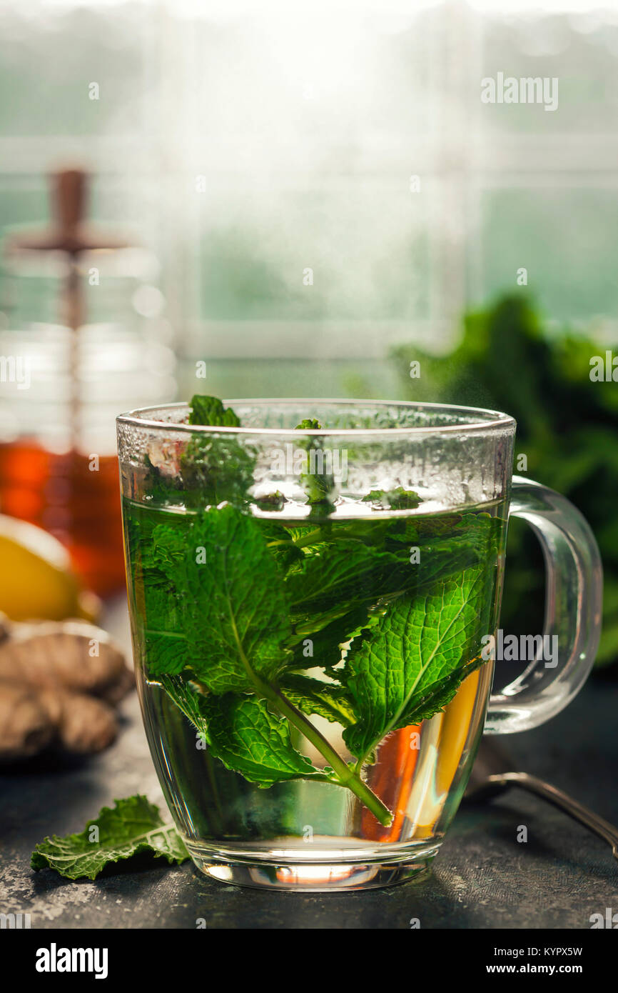 Fresh mint tea near the window. Cozy home or health concept Stock Photo