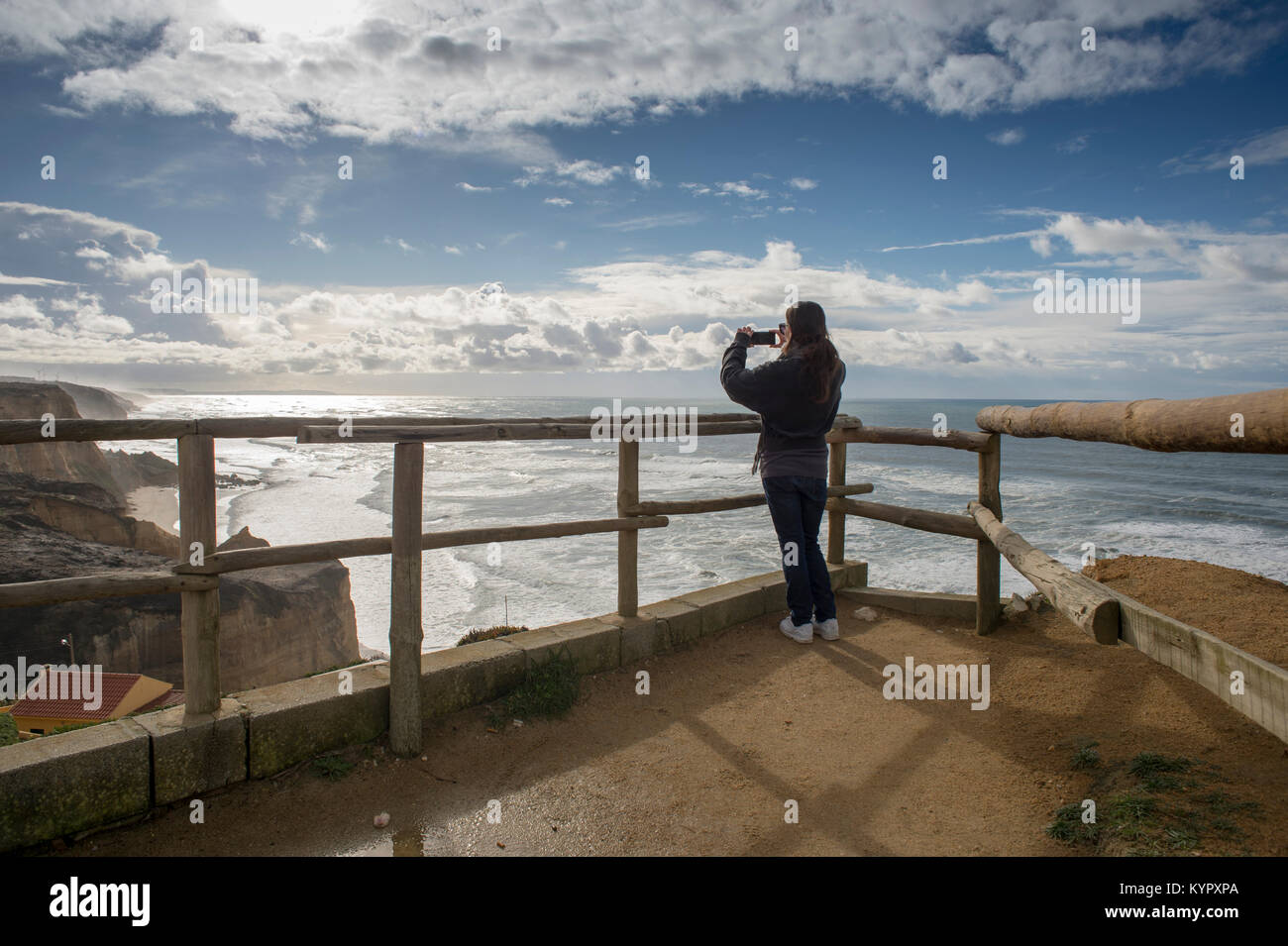 woman taking photos on her camera phone at the viewpoint at Vale Furado, nr Nazare, Portugal. Stock Photo