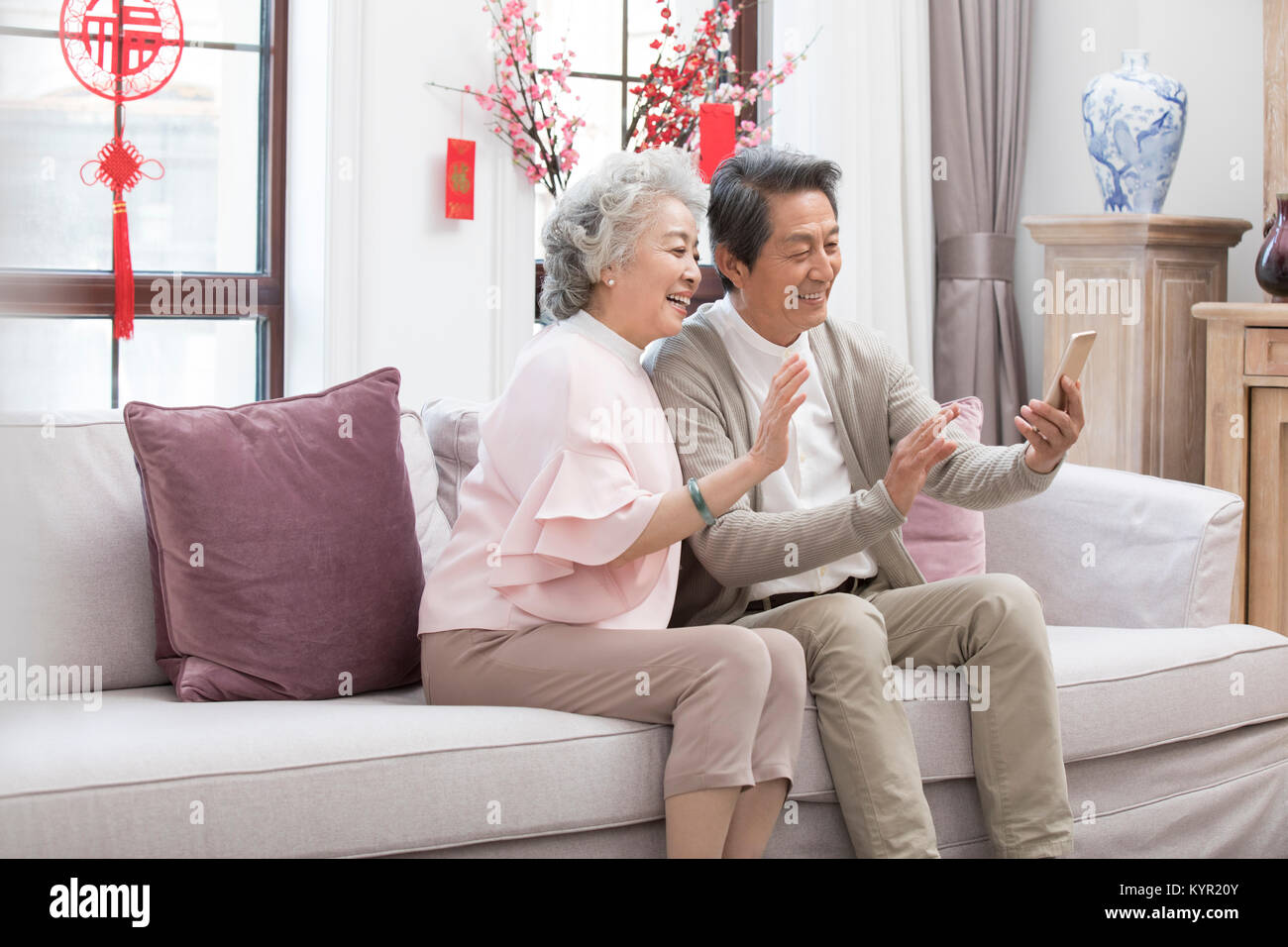 Happy Senior Couple Having Video Chat On Smart Phone During