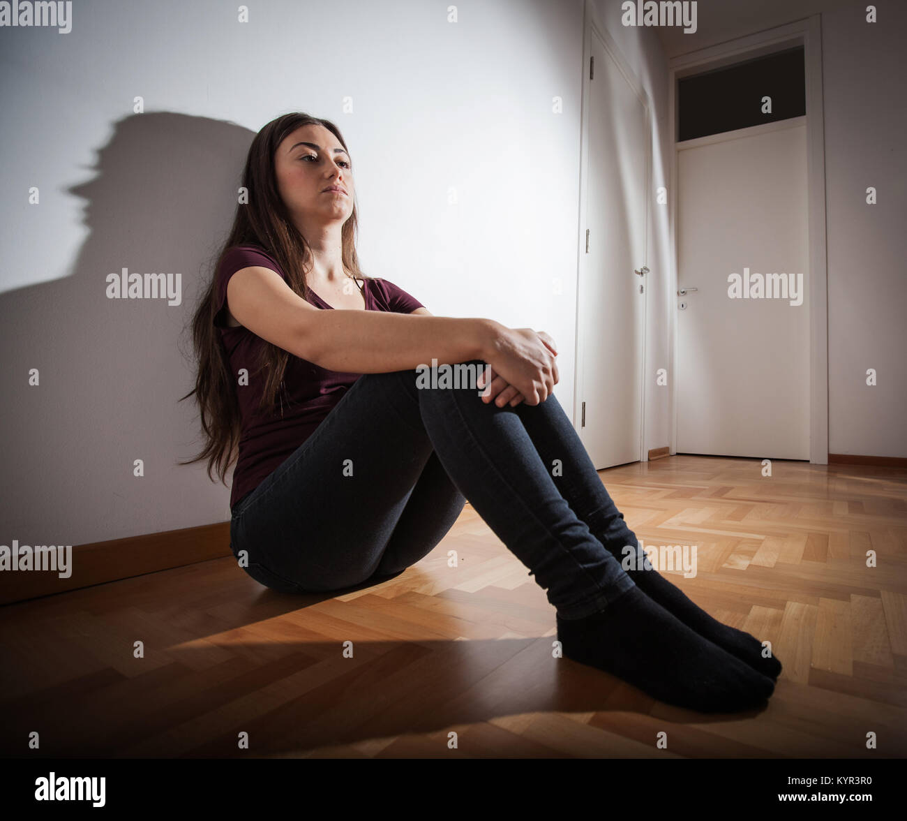 Depression teenager sitting on floor in empty room Stock Photo - Alamy