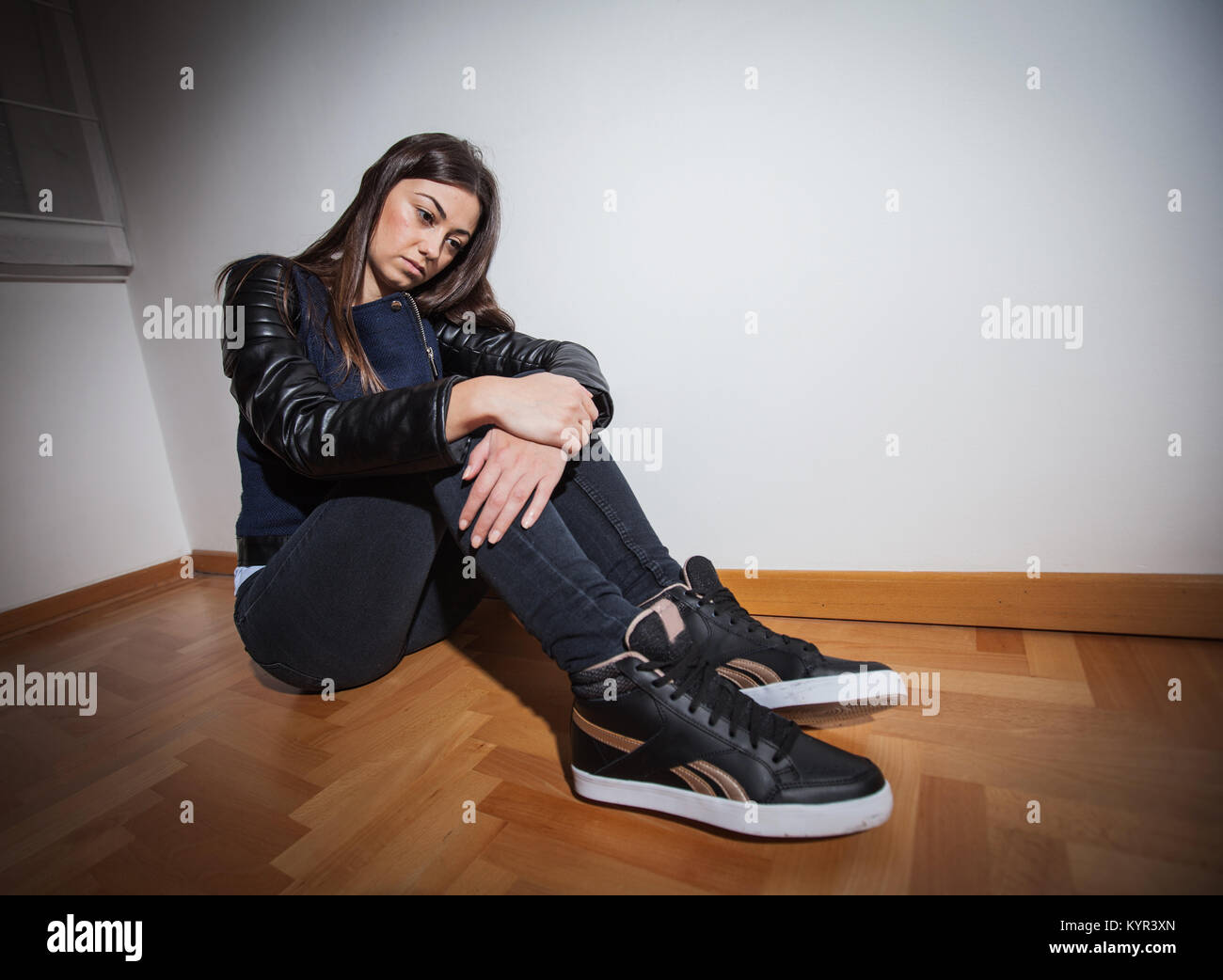 Depressed lonely unhappy young woman sitting on floor in empty room ...