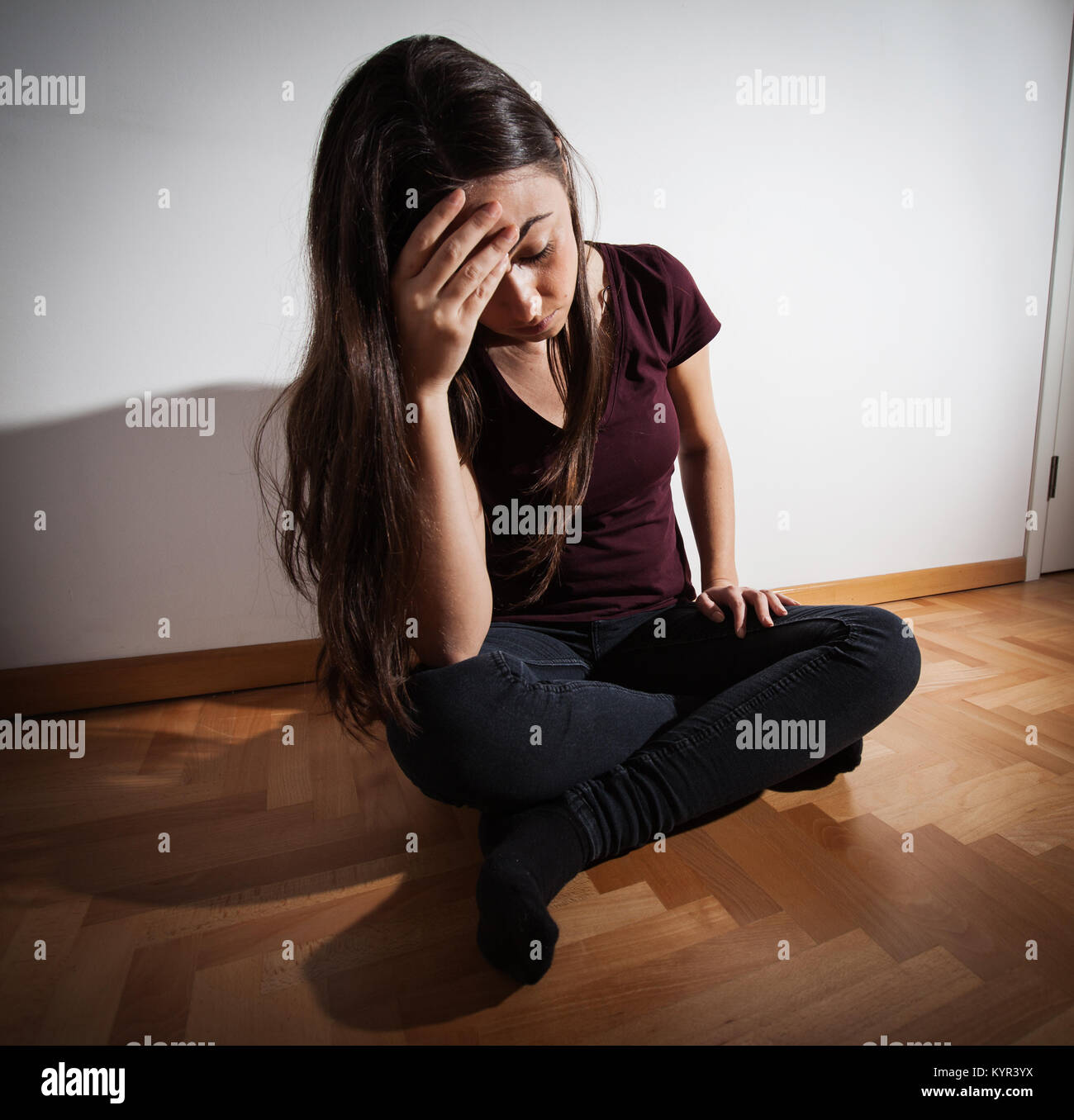 Depressed woman sitting on floor in empty room, female suffering from ...