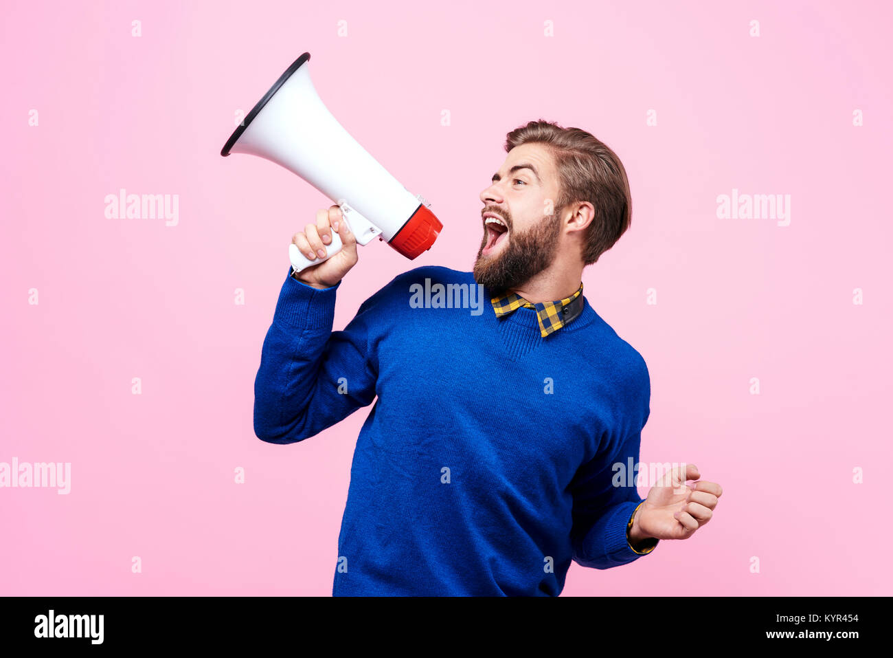 Cheerful man shouting into megaphone Stock Photo