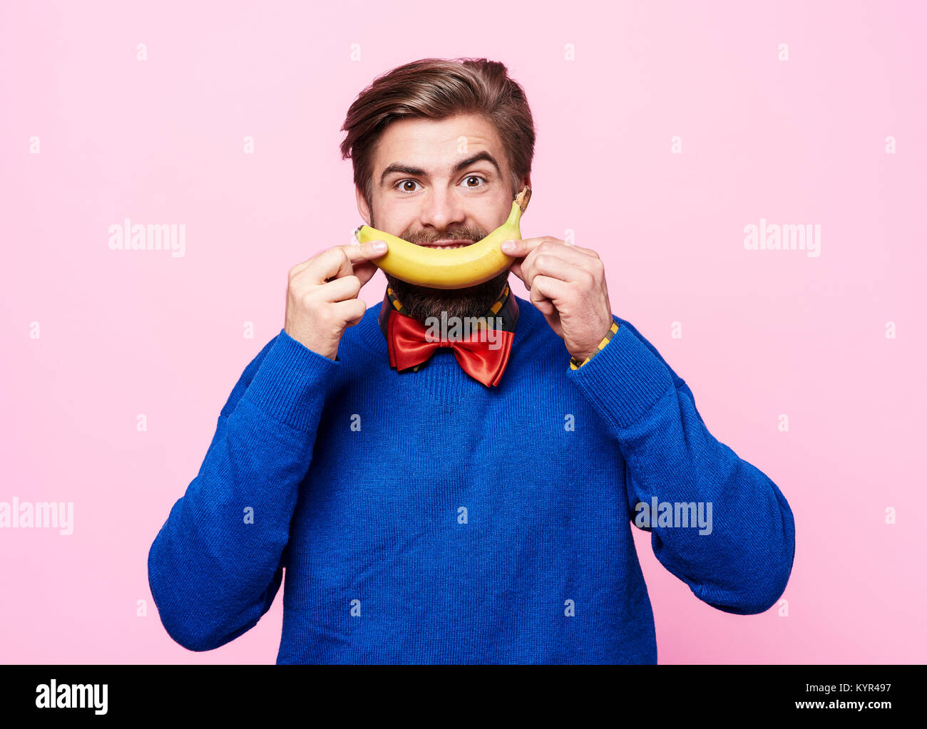 Man holding a banana in front of his  mouth Stock Photo