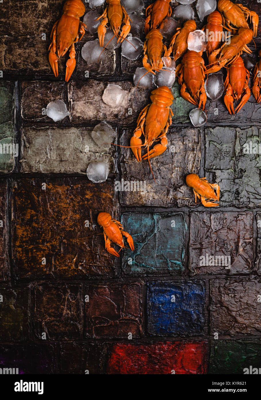 closeup view of gourmet lobsters with ice cubes on brick wall surface