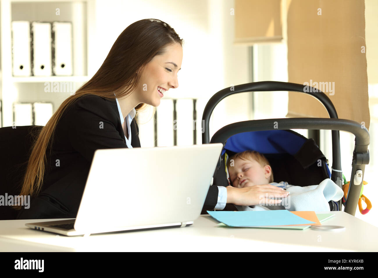 Happy mother working and taking care of her baby son at office Stock Photo