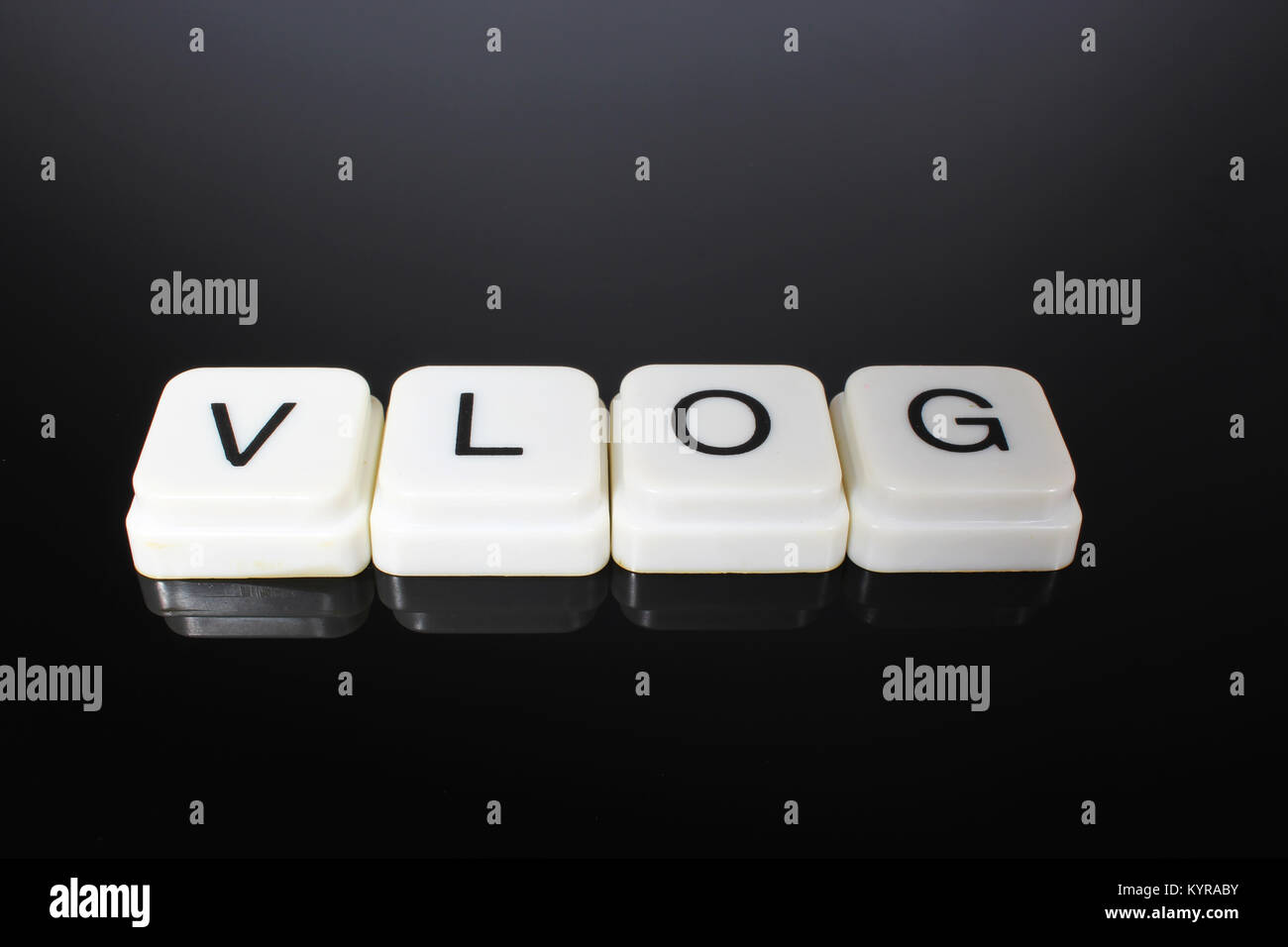 Vlog text word title caption label cover backdrop background. Alphabet letter toy blocks on black reflective background. White alphabetical letters. White educational toy block with words on mirror table. Stock Photo