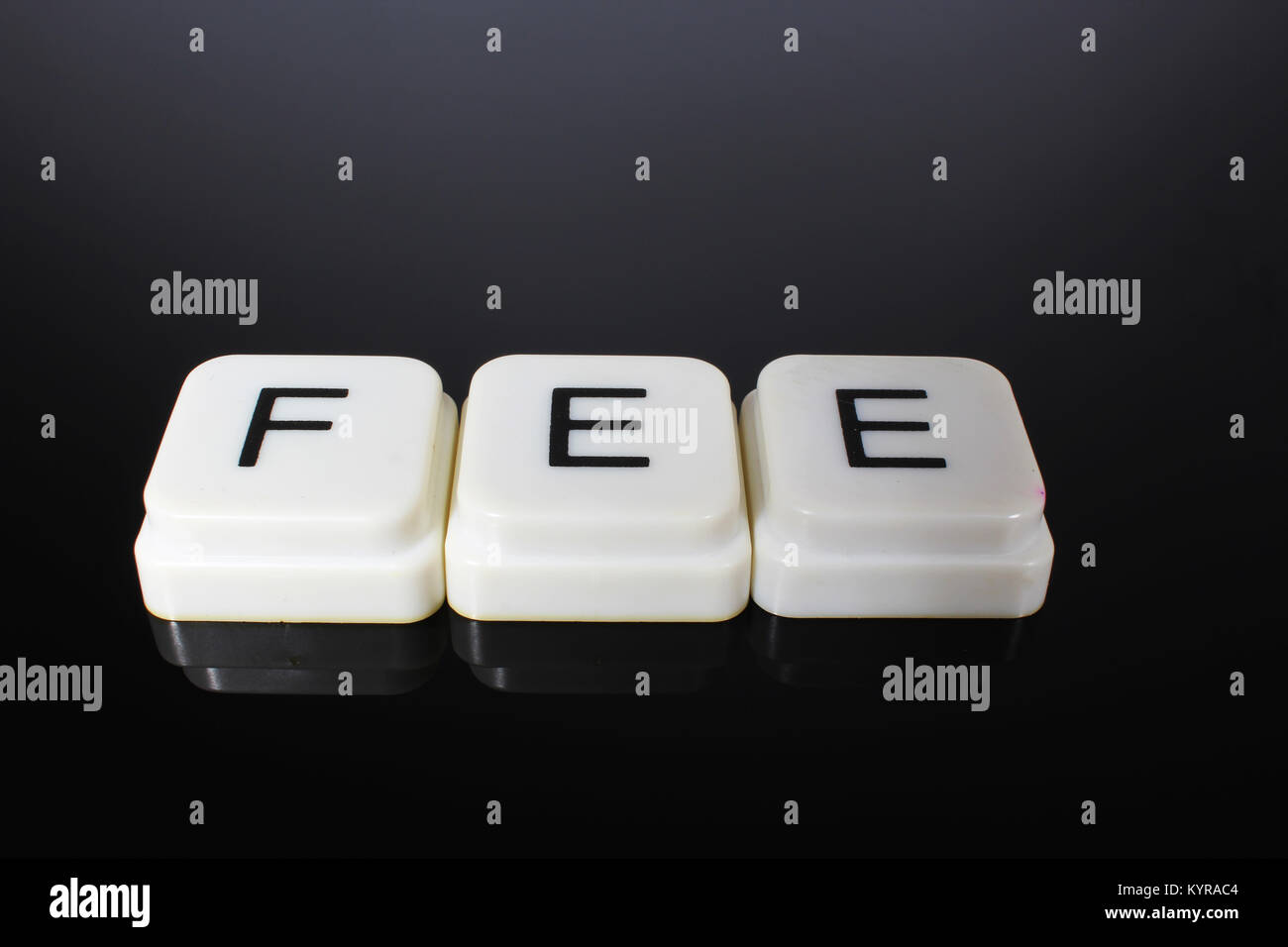 Fee text word title caption label cover backdrop background. Alphabet letter toy blocks on black reflective background. White alphabetical letters. White educational toy block with words on mirror table. Stock Photo