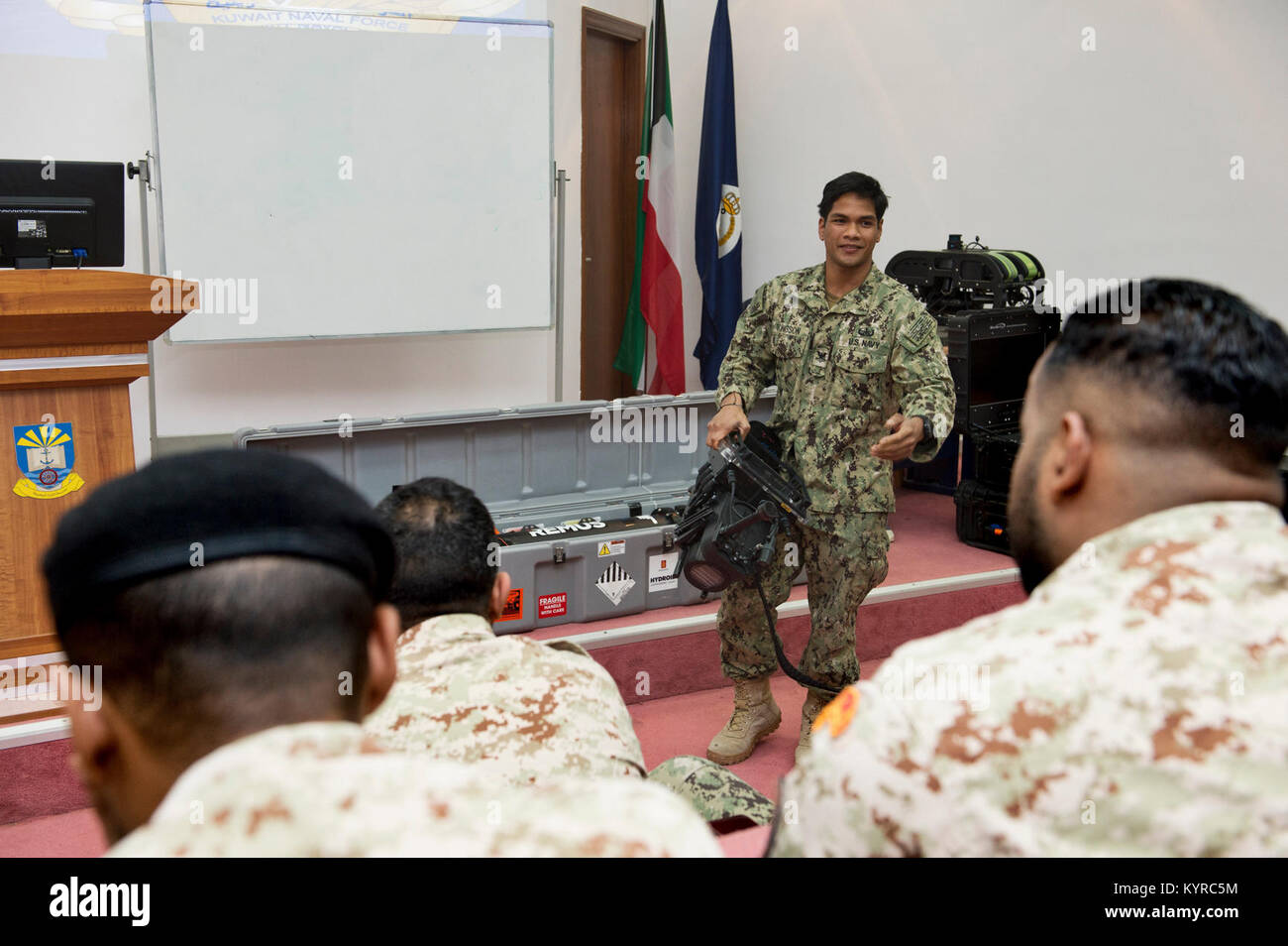 Mohammed Al-Ahmad Naval Base, KUWAIT (Jan. 7, 2018) Explosive Ordnance Disposal Technician 2nd Class Veranio-Xavier Tongson, assigned to Commander, Task Group 56.1, explains the capabilities of an underwater navigation system to Kuwait Naval Force explosive ordnance disposal technicians during a training evolution as part of exercise Eager Response 18. Eager Response 18 is a bilateral explosive ordnance disposal military exercise between the State of Kuwait and the United States. The exercise fortifies military-to-military relationships between the Kuwait Naval Force and U.S. Navy, advances th Stock Photo