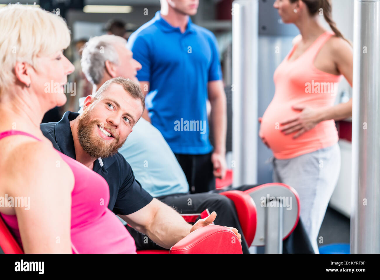 Senior woman in group with pregnant woman working out at the gym Stock Photo