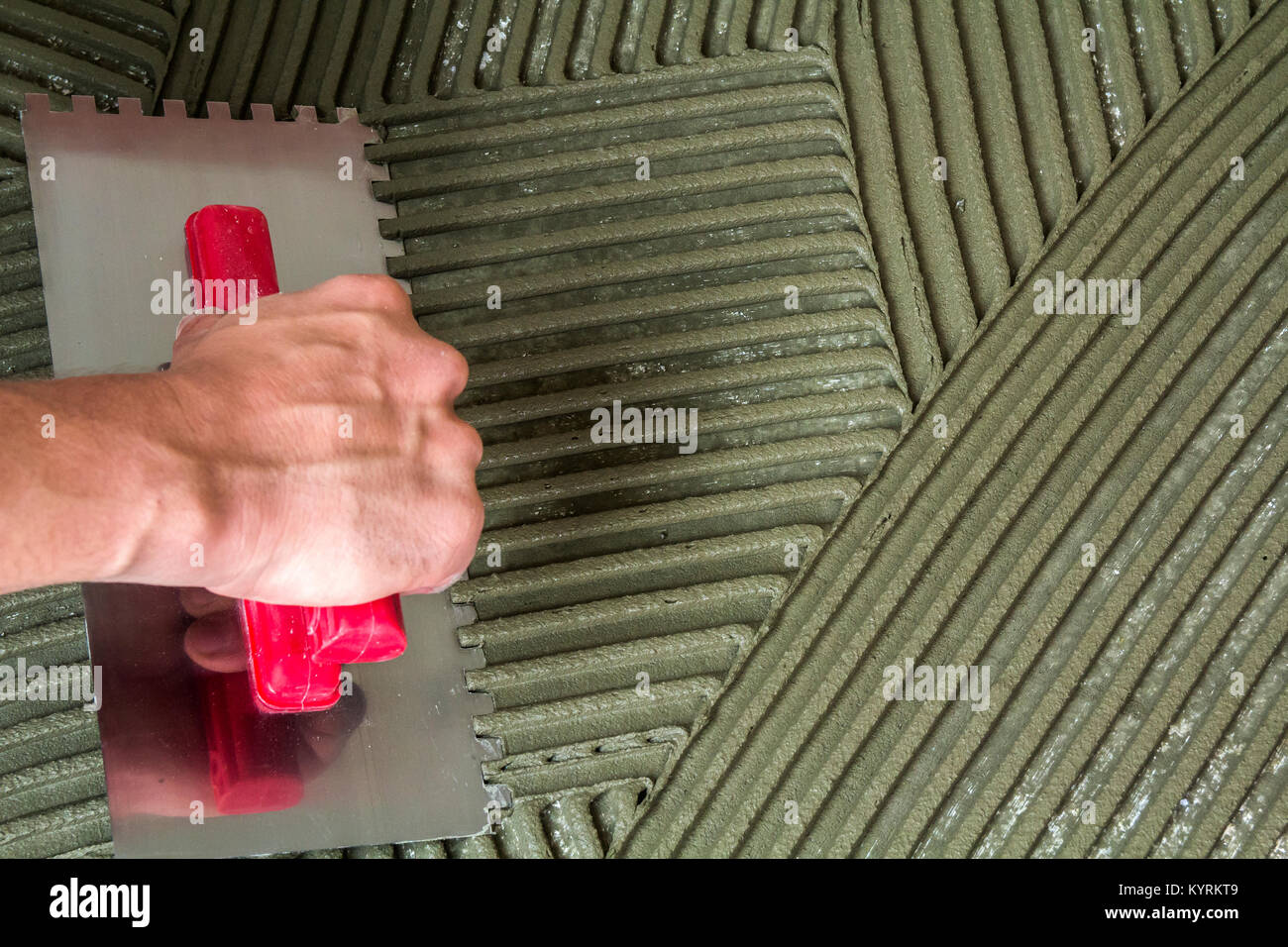worker applying tile adhesive glue on the floor Stock Photo - Alamy