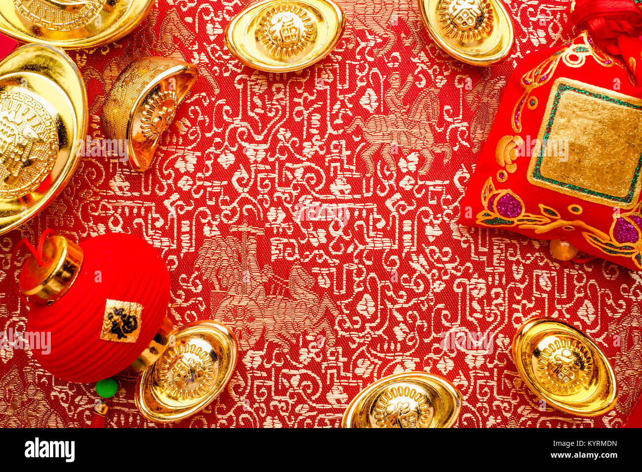 Chinese new year decoration,close up golden ingots ( ang pow )and lamp on red oriental pattern fabric hexagon box with chinese style pattern on red,Ch Stock Photo