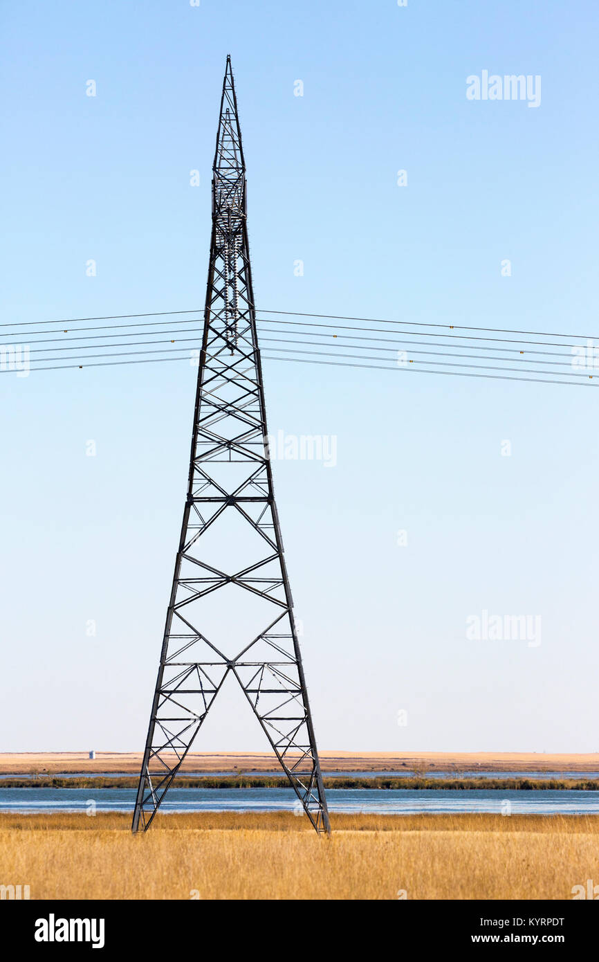 Transmission tower along prairie lake Stock Photo