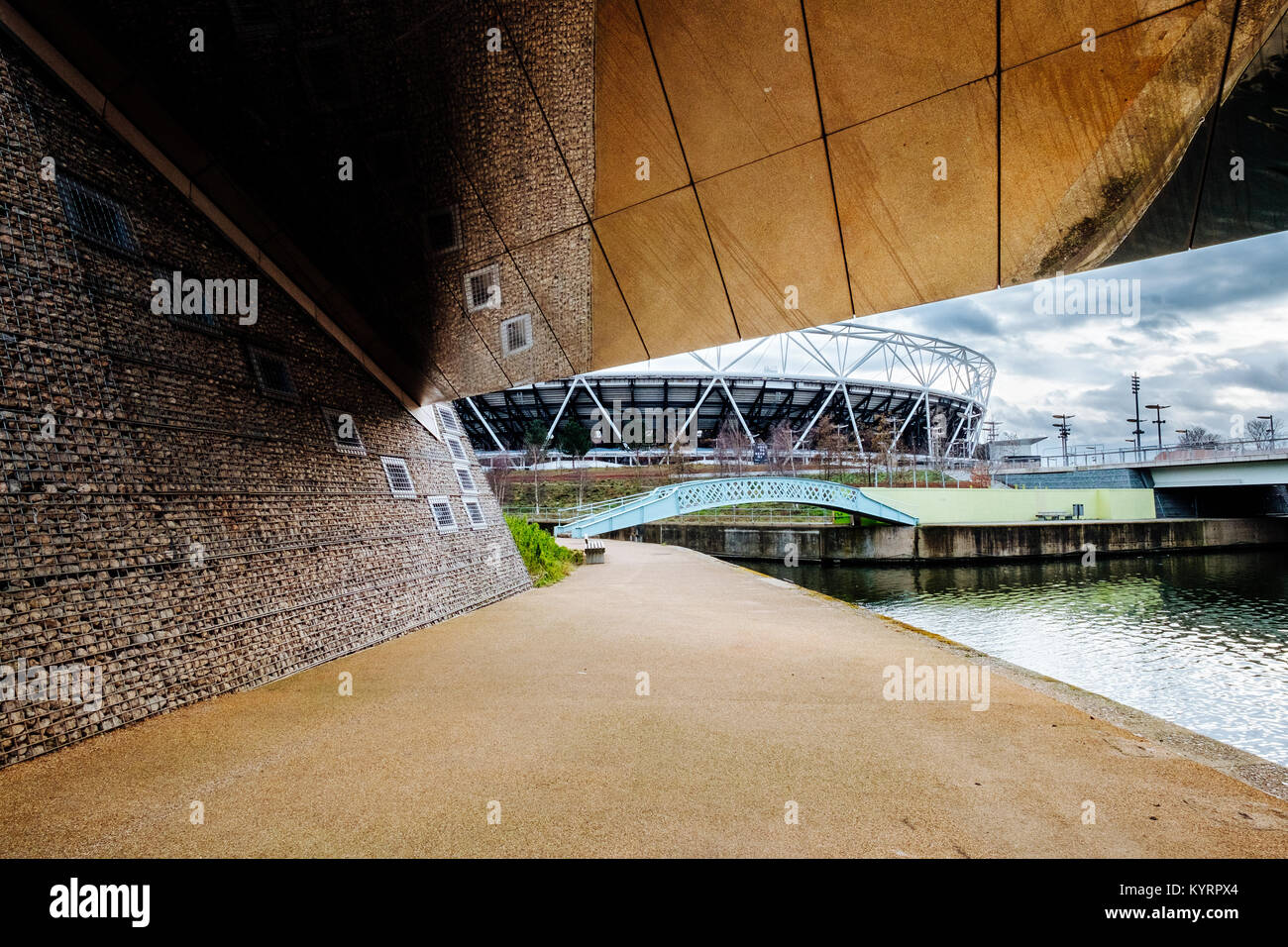 A reflective bridge with the London Olympic Stadium visible in the background Stock Photo