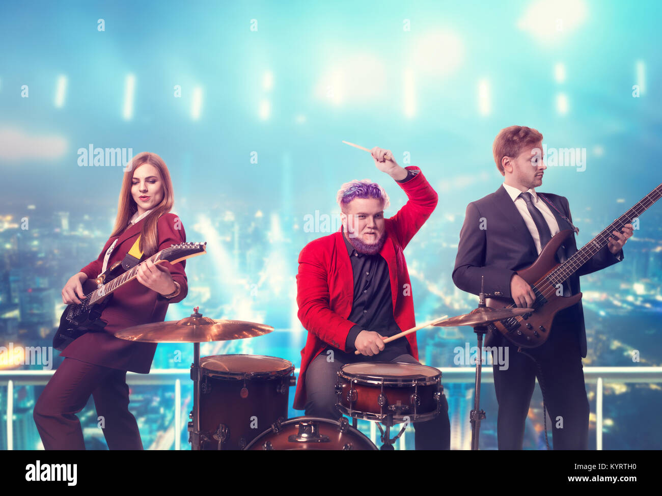 Musical group in suits, performing on the rooftop, retro style, night cityscape on background. Guitarists and drummer, rock band Stock Photo