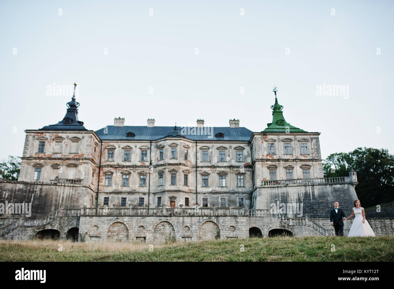 Fabulous wedding couple posing in front of an old medieval castle in ...