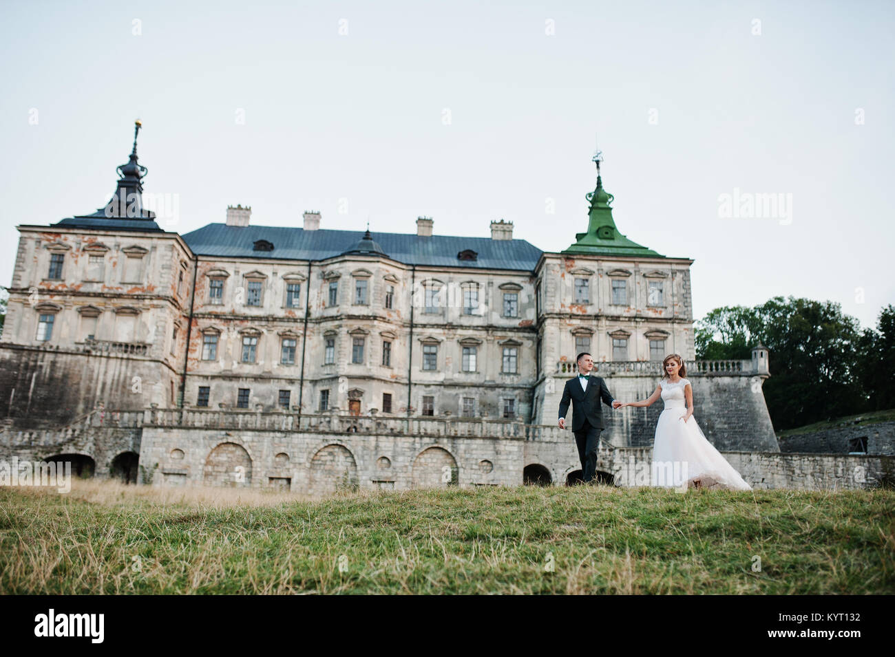 Fabulous wedding couple posing in front of an old medieval castle in ...