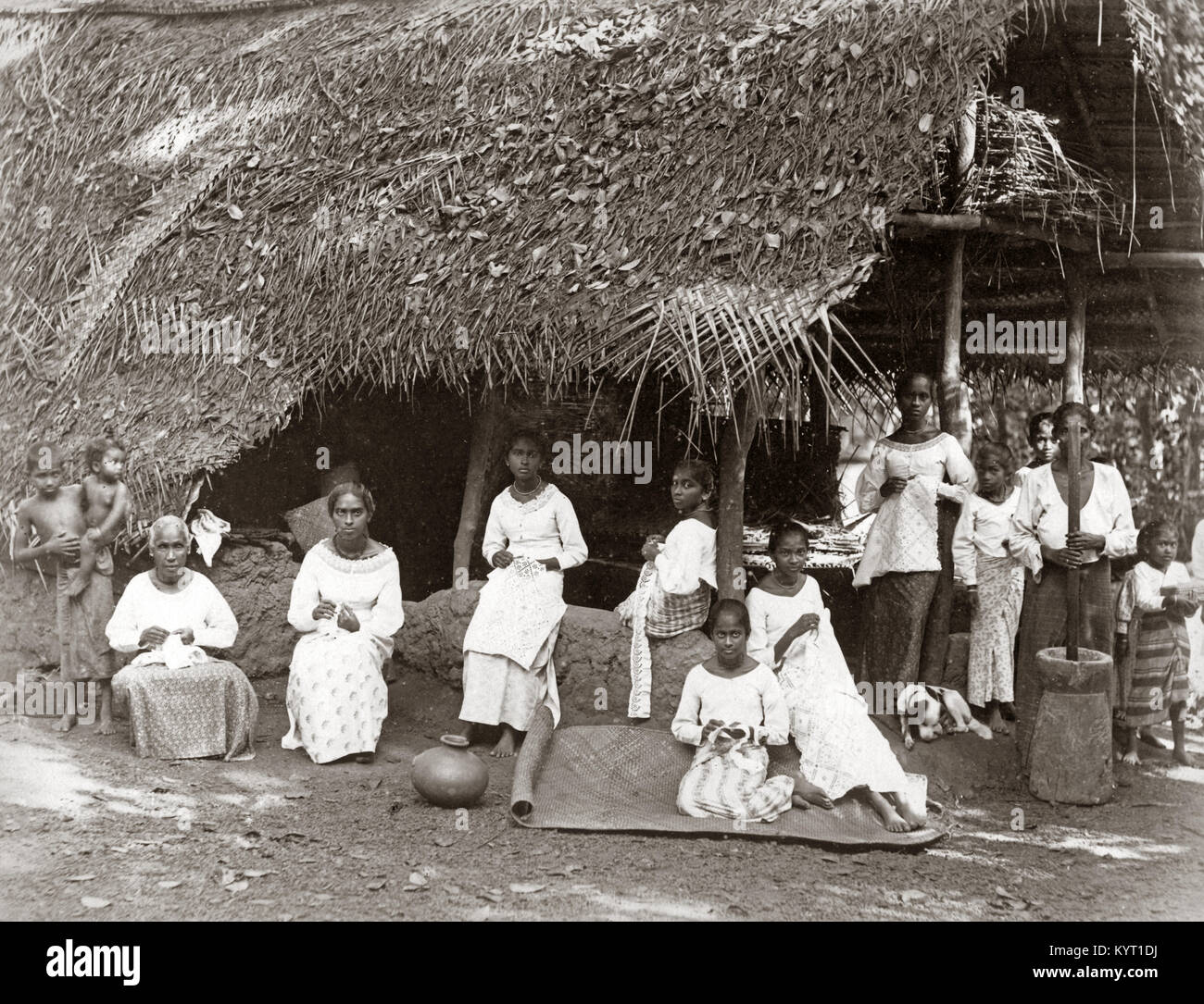 Group of women and children, straw roofed house, India or Ceylon (Sri