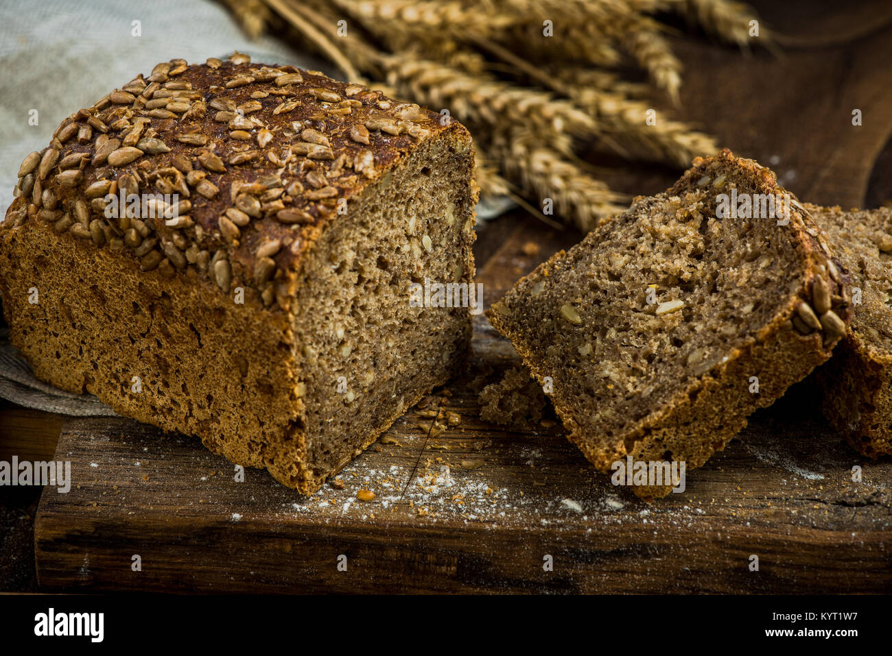 Wholegrain bread with seeds sliced on board Stock Photo - Alamy
