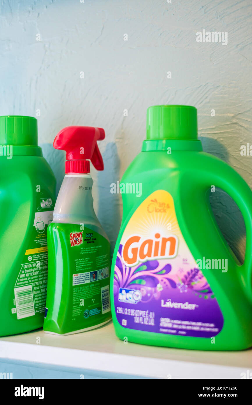 A laundry room shelf containing Gain laundry detergent and a bottle of spray & wash, a spot remover. Oklahoma, USA. Stock Photo