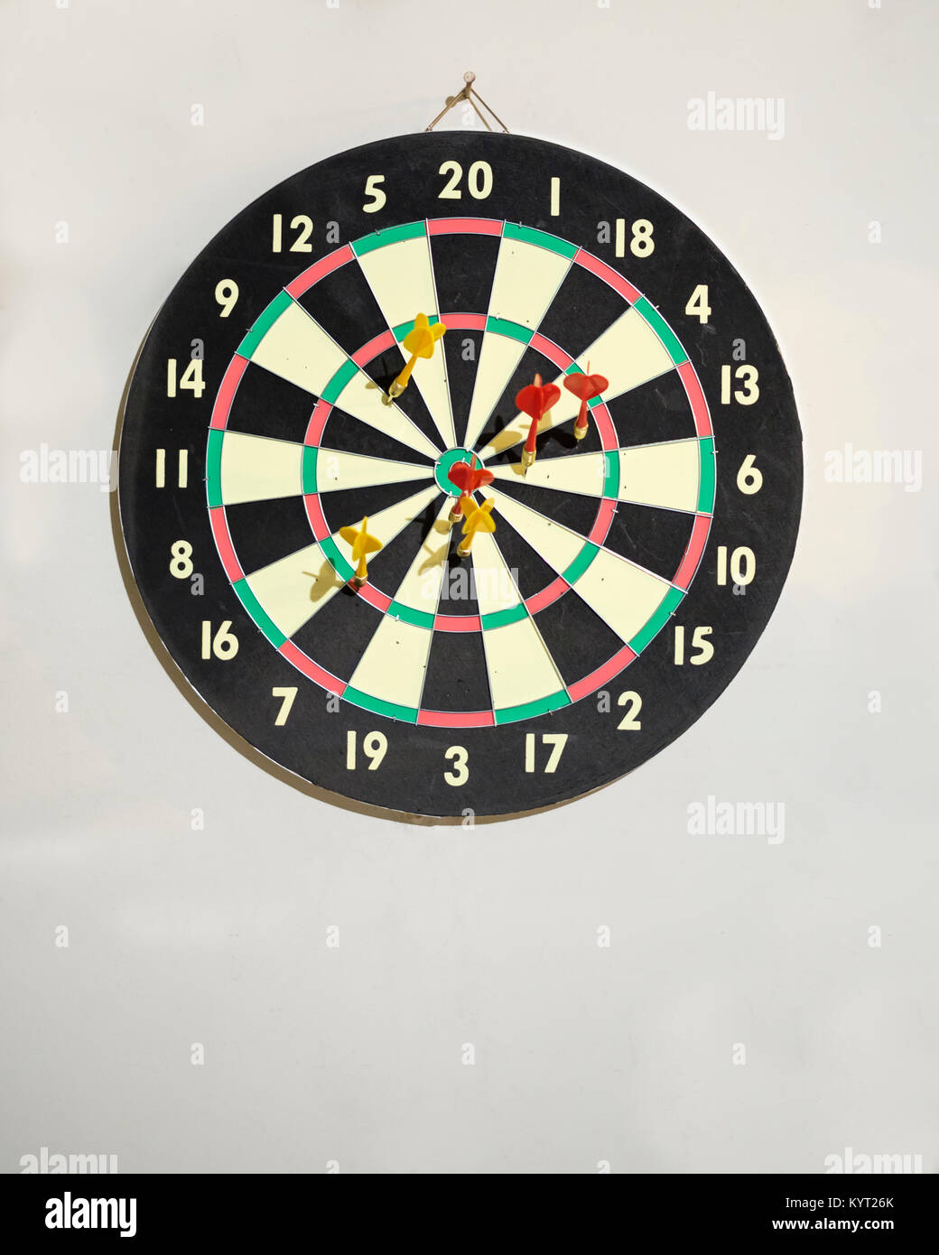 A game dartboard and darts hanging on the wall inside of a garage in Oklahoma, USA. Stock Photo