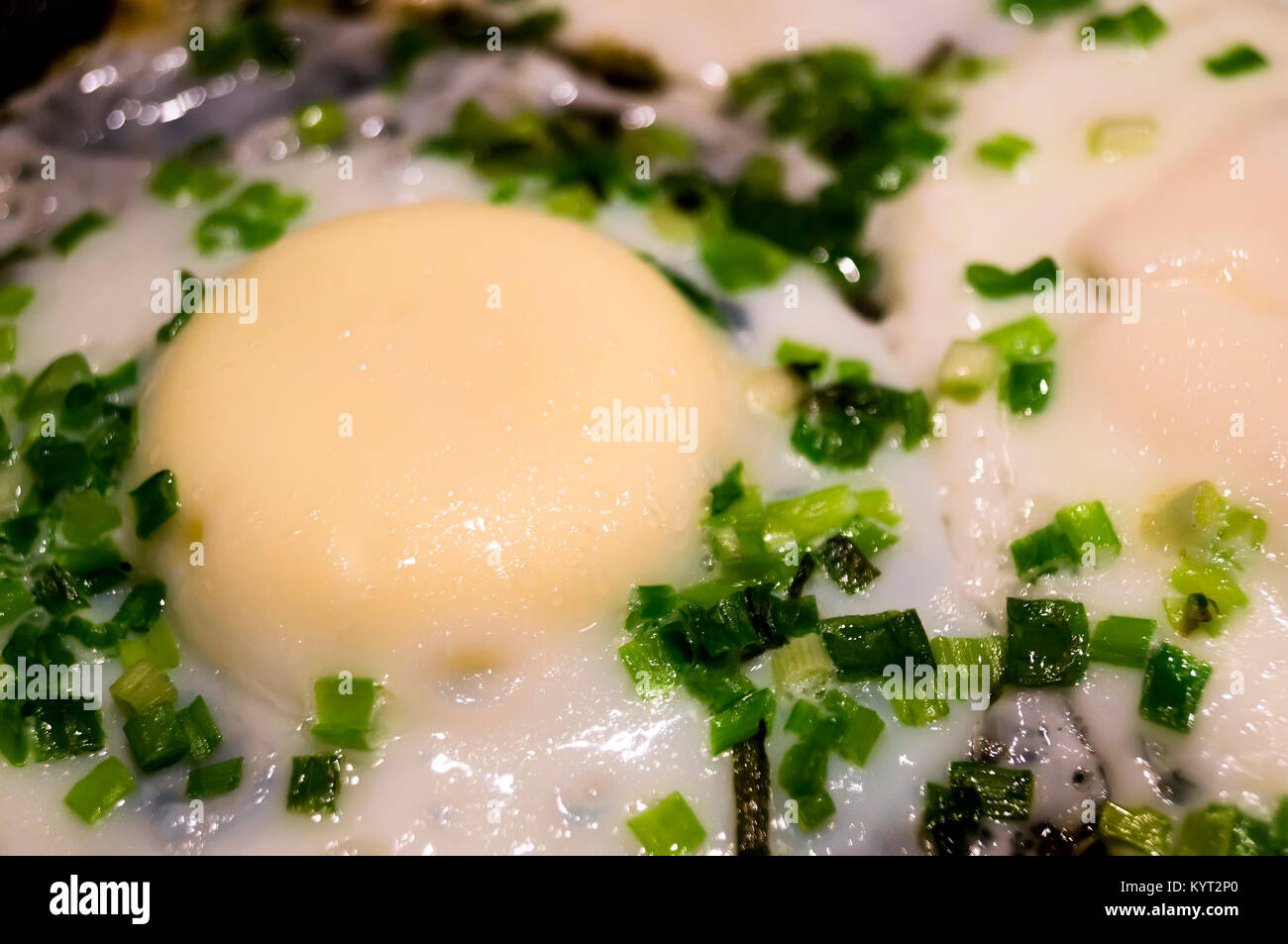 fried eggs in a frying pan close up background Stock Photo - Alamy