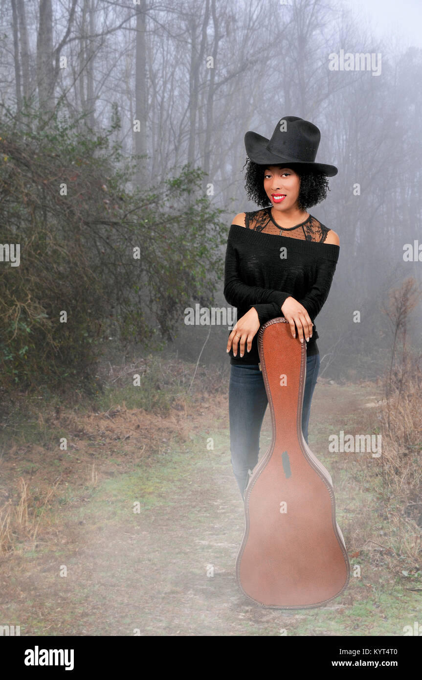 Beautiful young country western woman with an acoustic guitar Stock