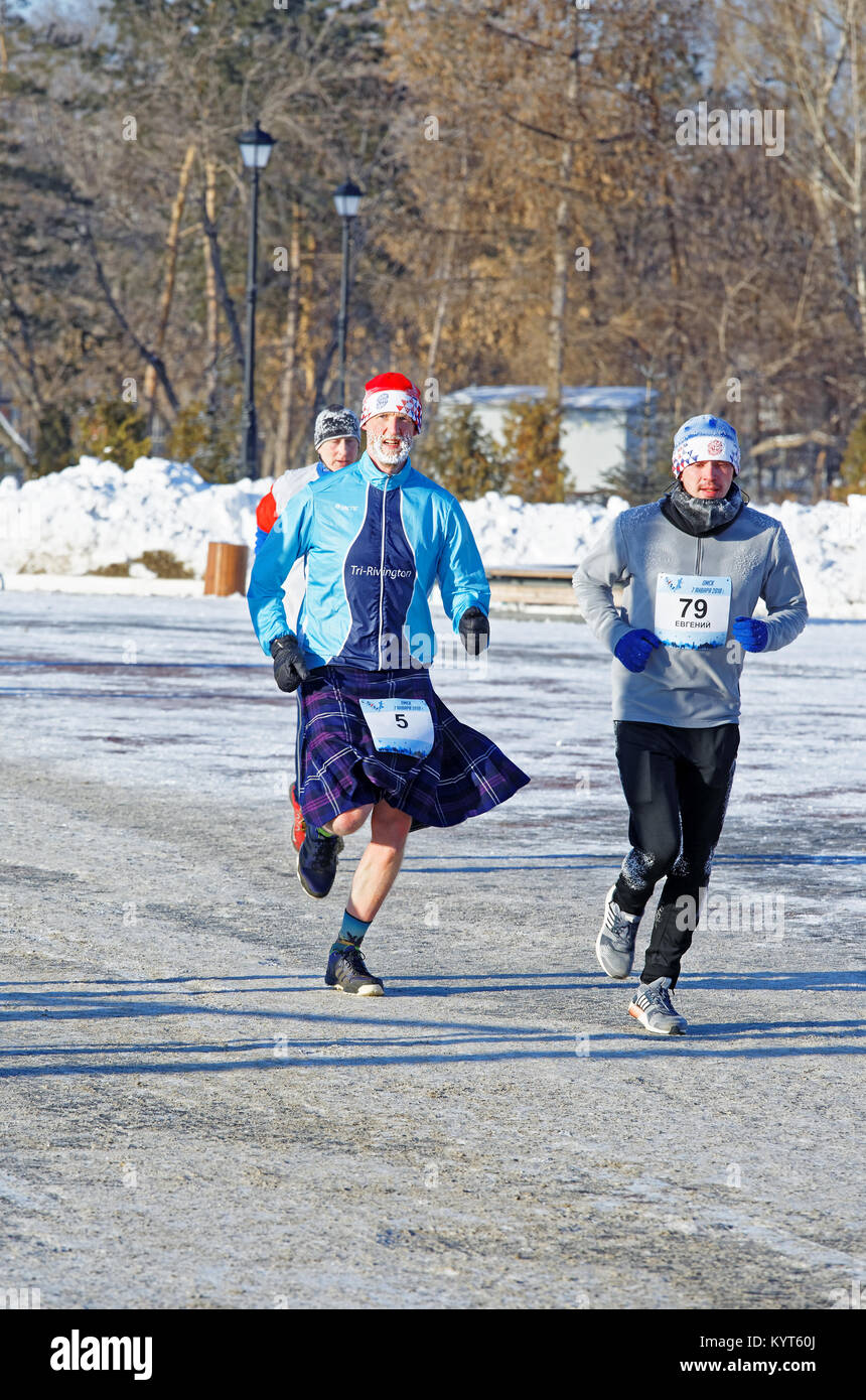 Editorial. Omsk,Russia - January, 07 2018. Runners of different nationalities and ages running along the Embankment of Tukhachevsky Stock Photo