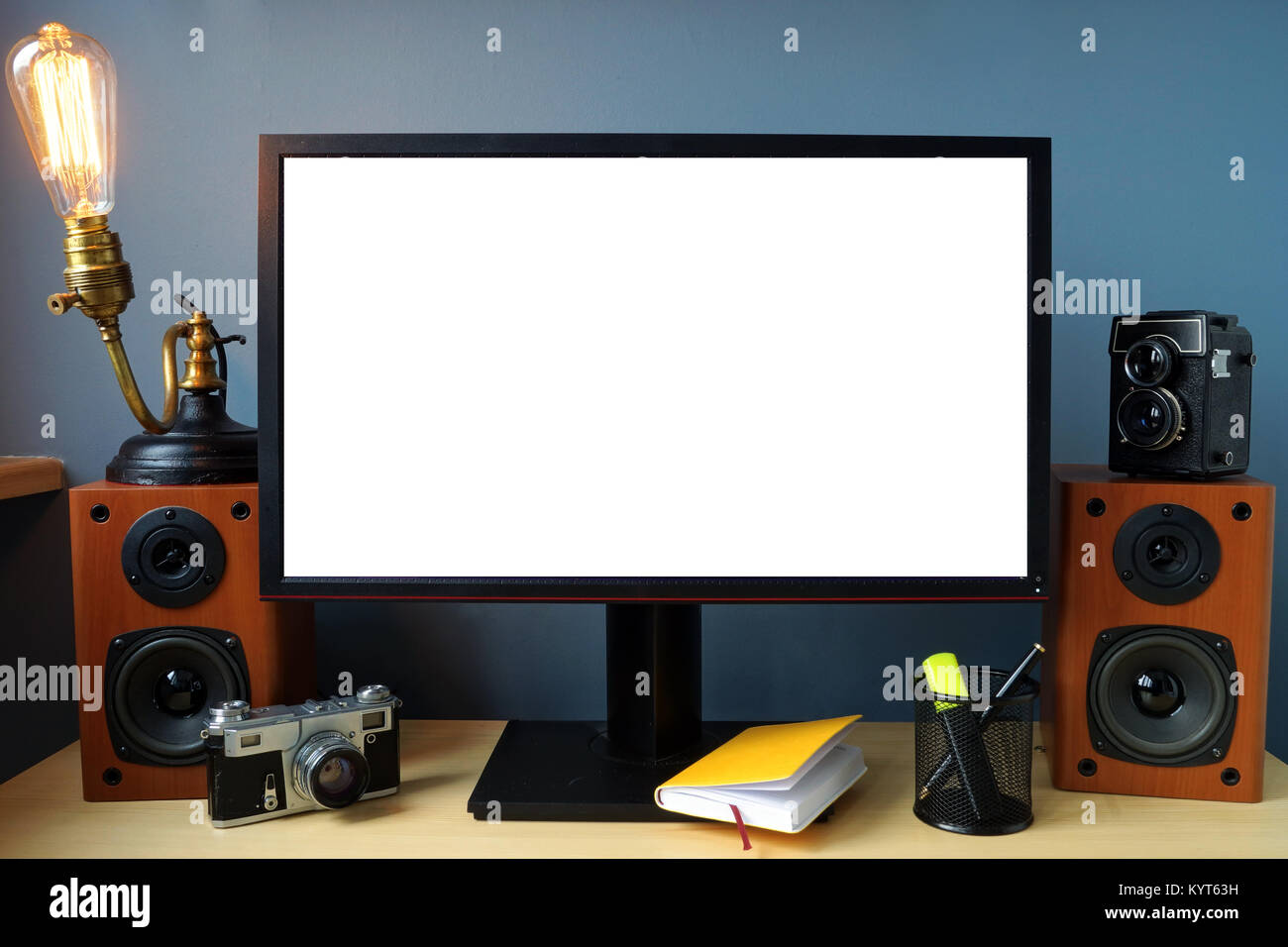 Mock-up. Monitor on an office desk with vintage lamp and photo camera. Stock Photo