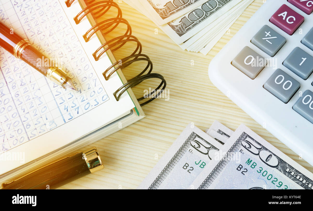 Small business accounting. Ledger, pen, money and calculator. Stock Photo