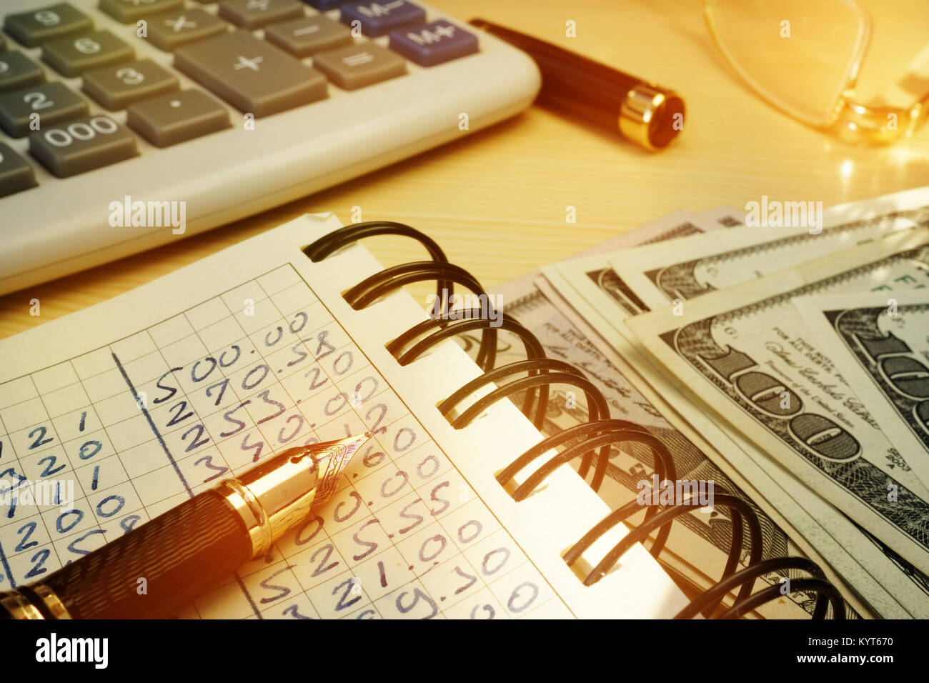 Budgeting money. Book with calculations, calculator and dollars. Stock Photo