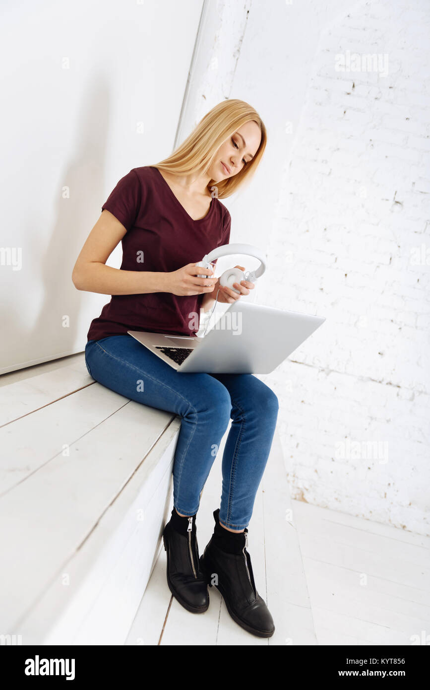 Attentive female person wearing headphones Stock Photo