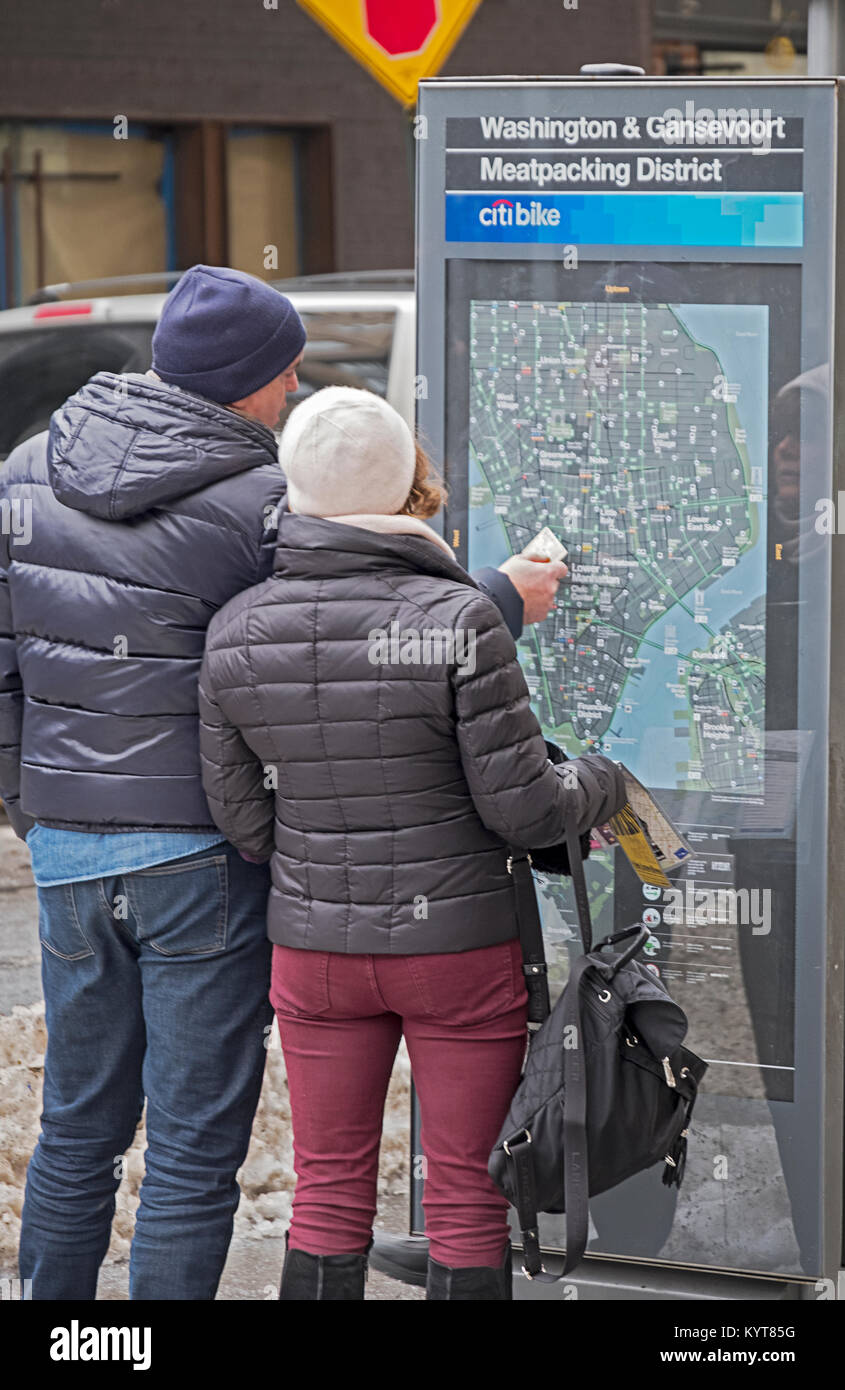 A tourist couple check out a Citibike street map on Washington St. in the Meatpacking district of lower Manhattan, New York City. Stock Photo