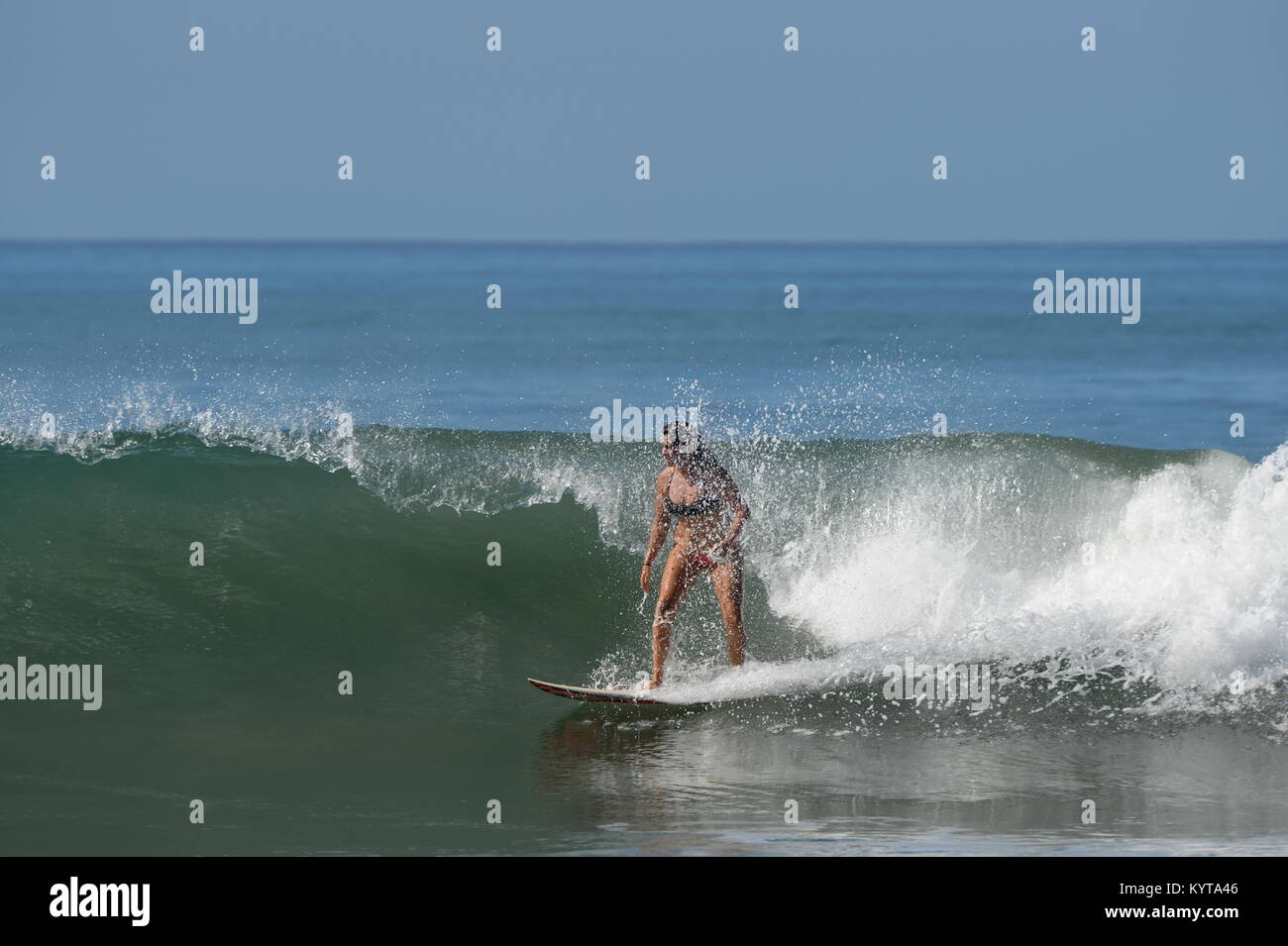 Girl Surfing surrounded in spray on the Nicoya Peninsula Stock Photo